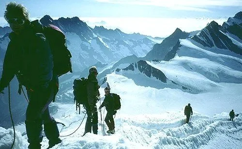 Our mountaineers aiming for an Alpine summit with snow-covered peaks in the background.