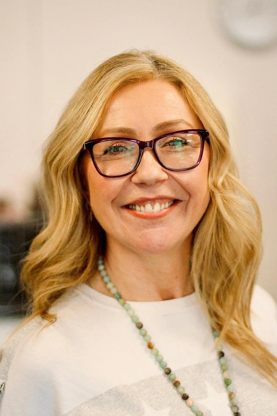 Jane Wrafter Counselling in Muswell Hill, with blonde hair, wearing glasses, smiling, in an indoor setting.