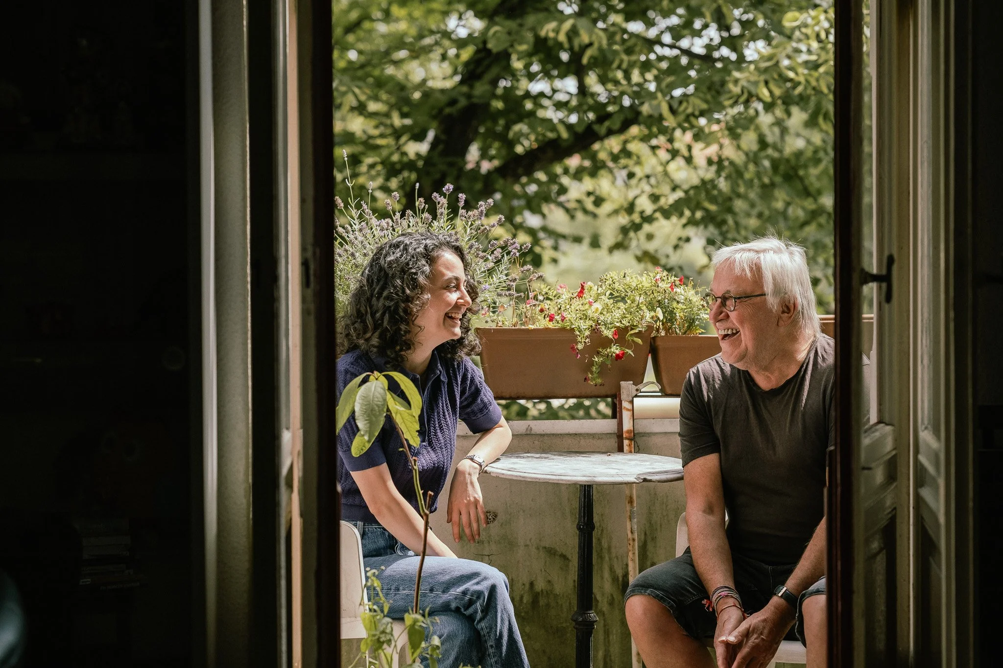 Generationen-WG: Zwei Generationen sitzen auf dem Balkon.