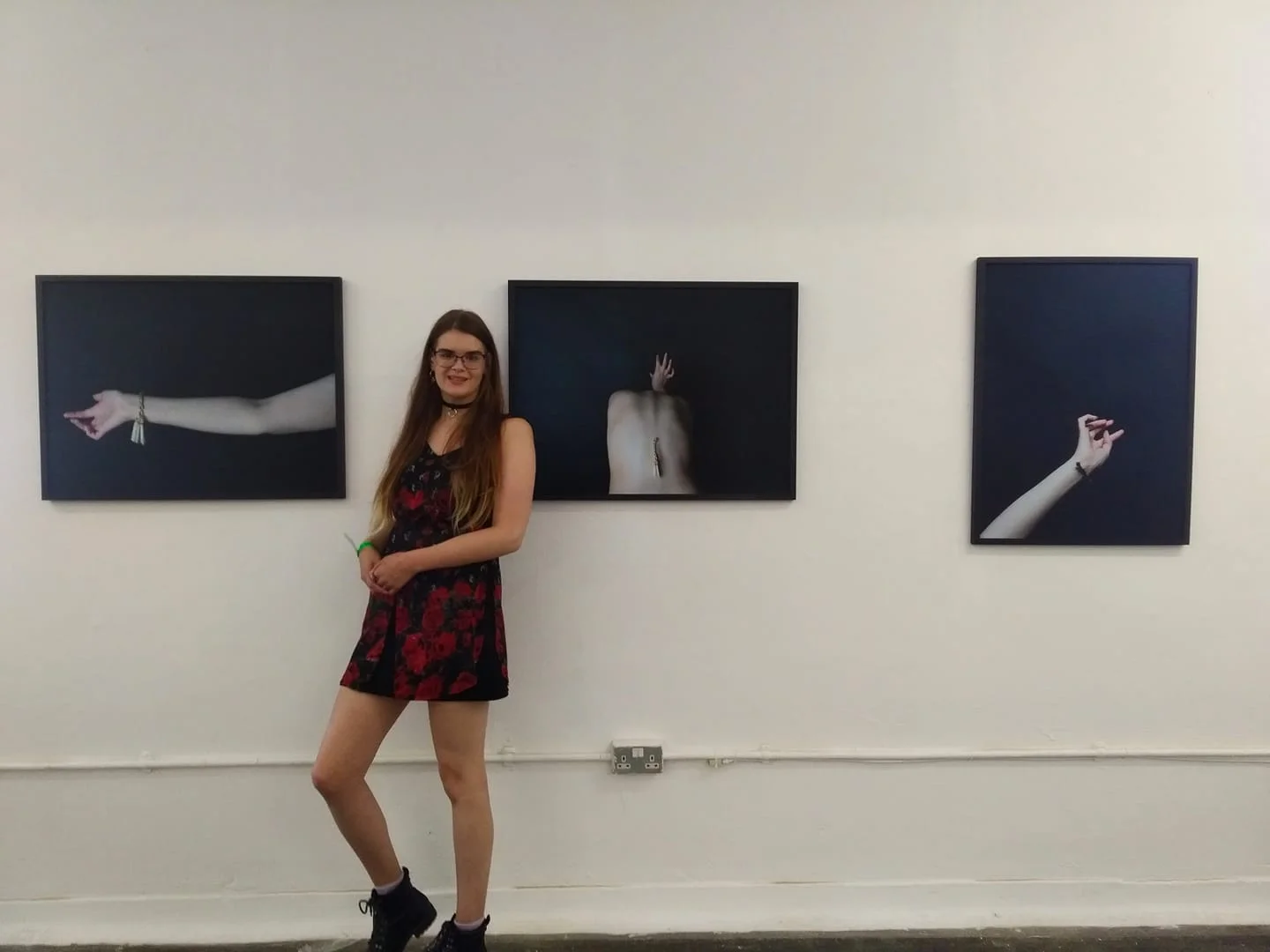 Danielle standing in front of an exhibition of her own work