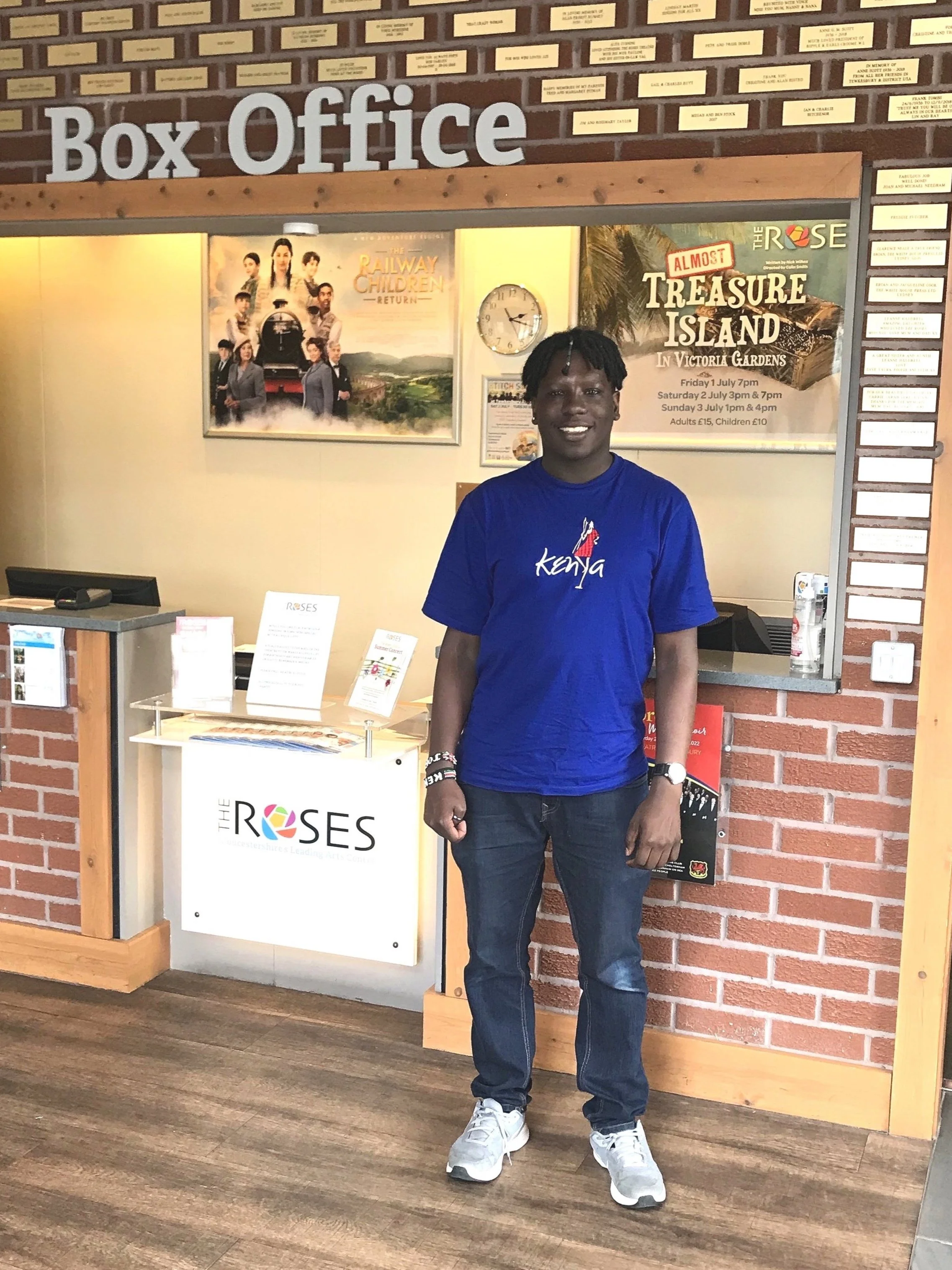 Jordan stands in front of the box office in the theatre.