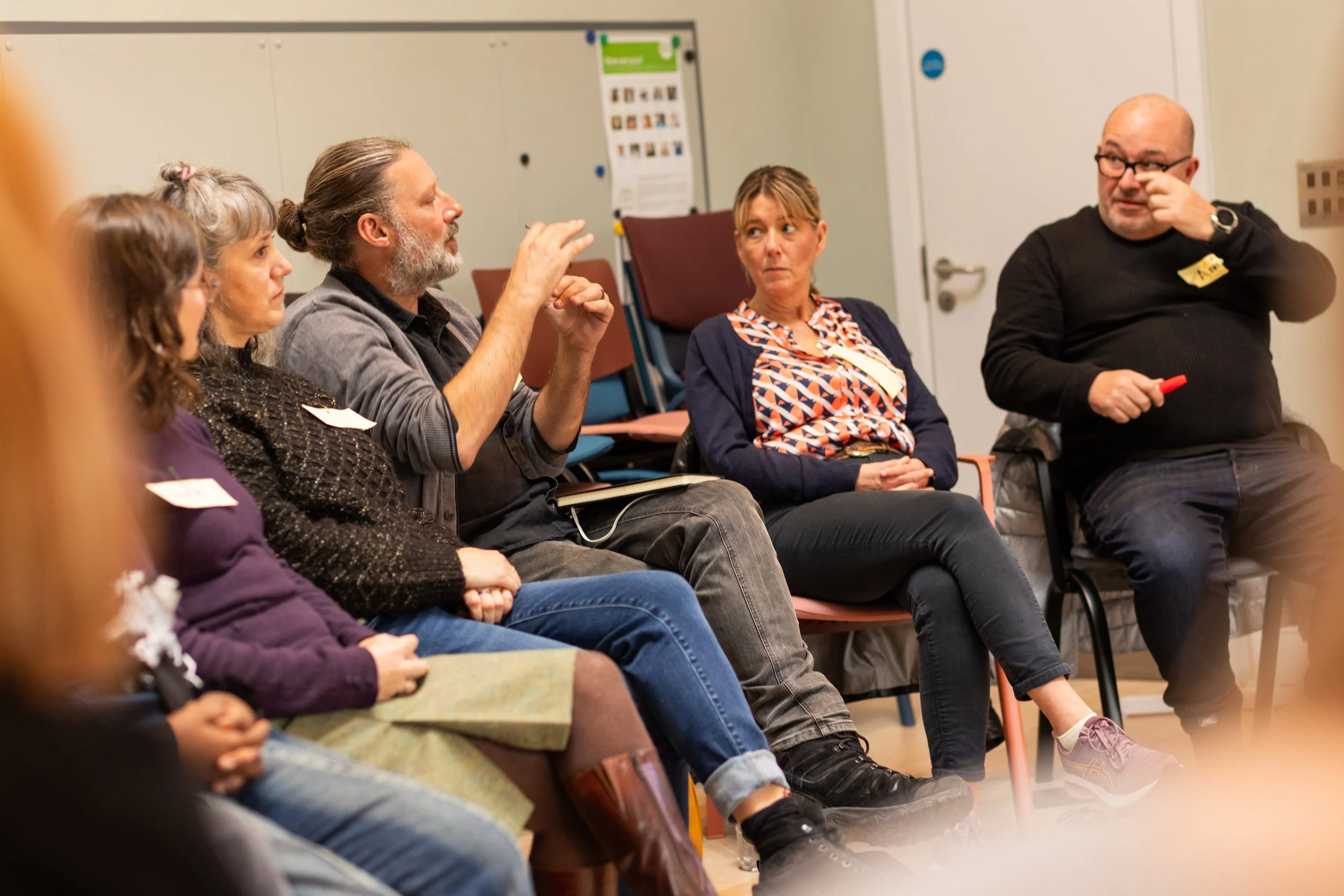 A group of people sitting in a circle, engaged in a discussion at a Create Gloucestershire event.