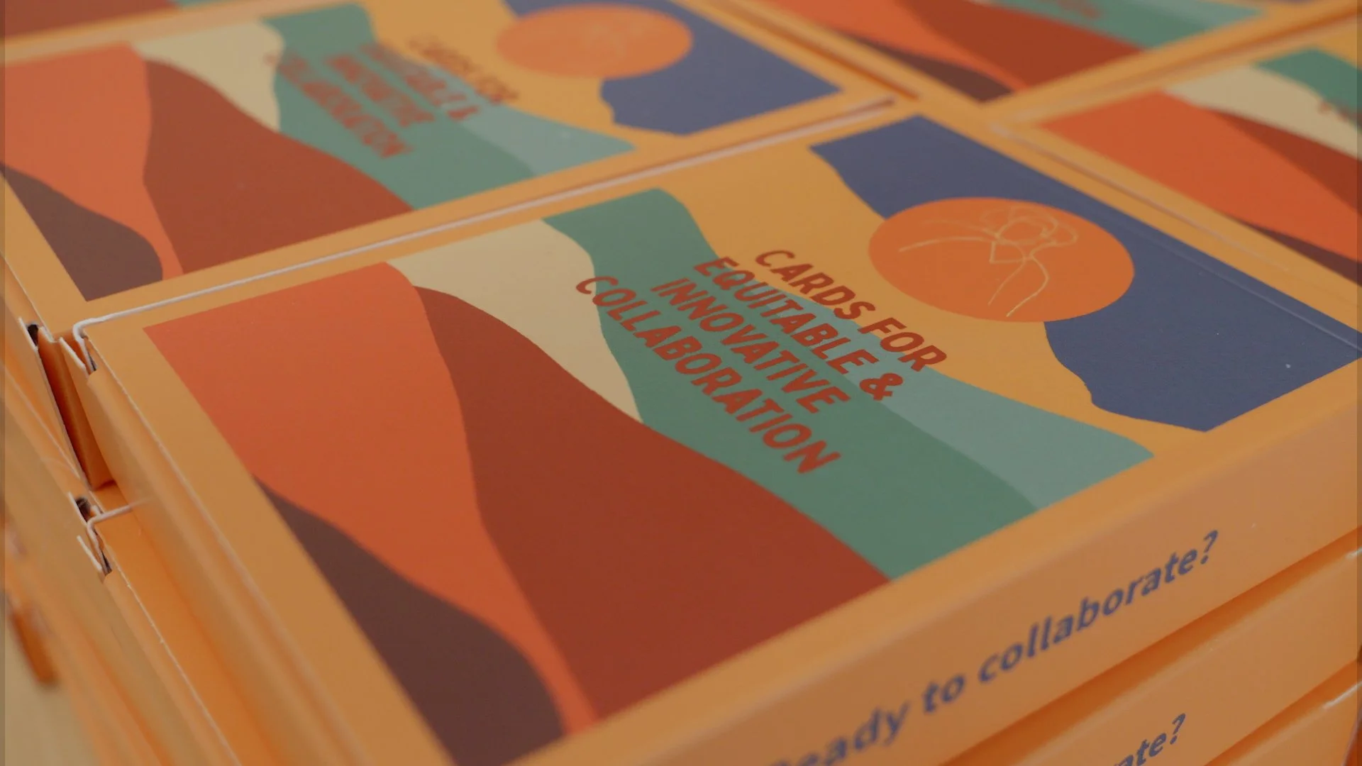 Boxes of collaboration cards with Lucy Turner’s layered hills artwork, at a Create Glos event.