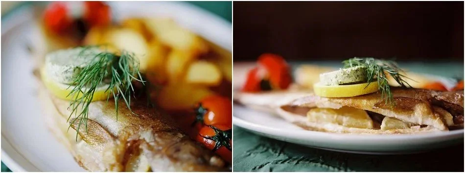 Bild mit gegrilltem Fisch mit Zitronenscheibe, Kräutern und Gemüse auf einem Teller