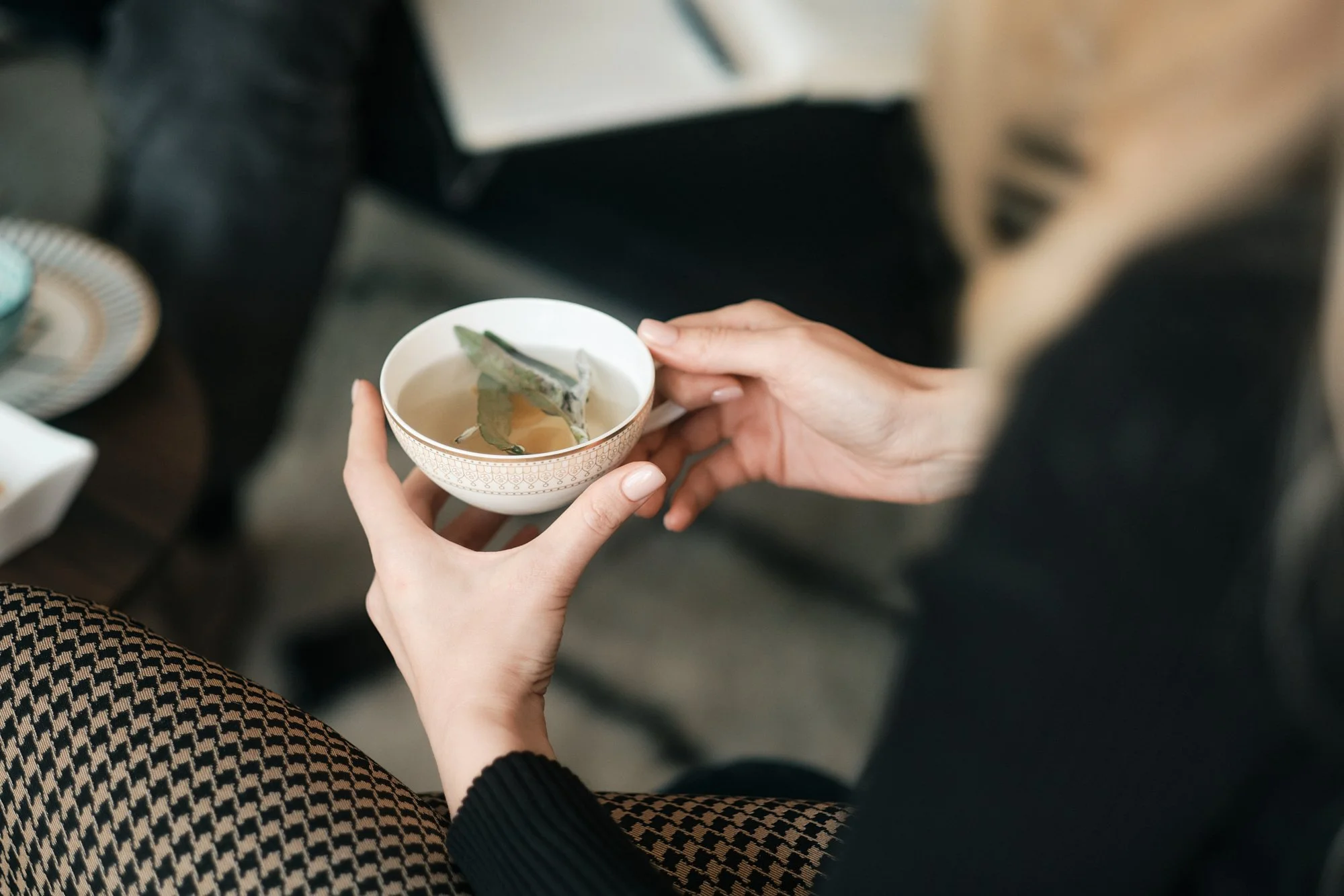Person hält eine Teetasse mit Teeblättern darin.