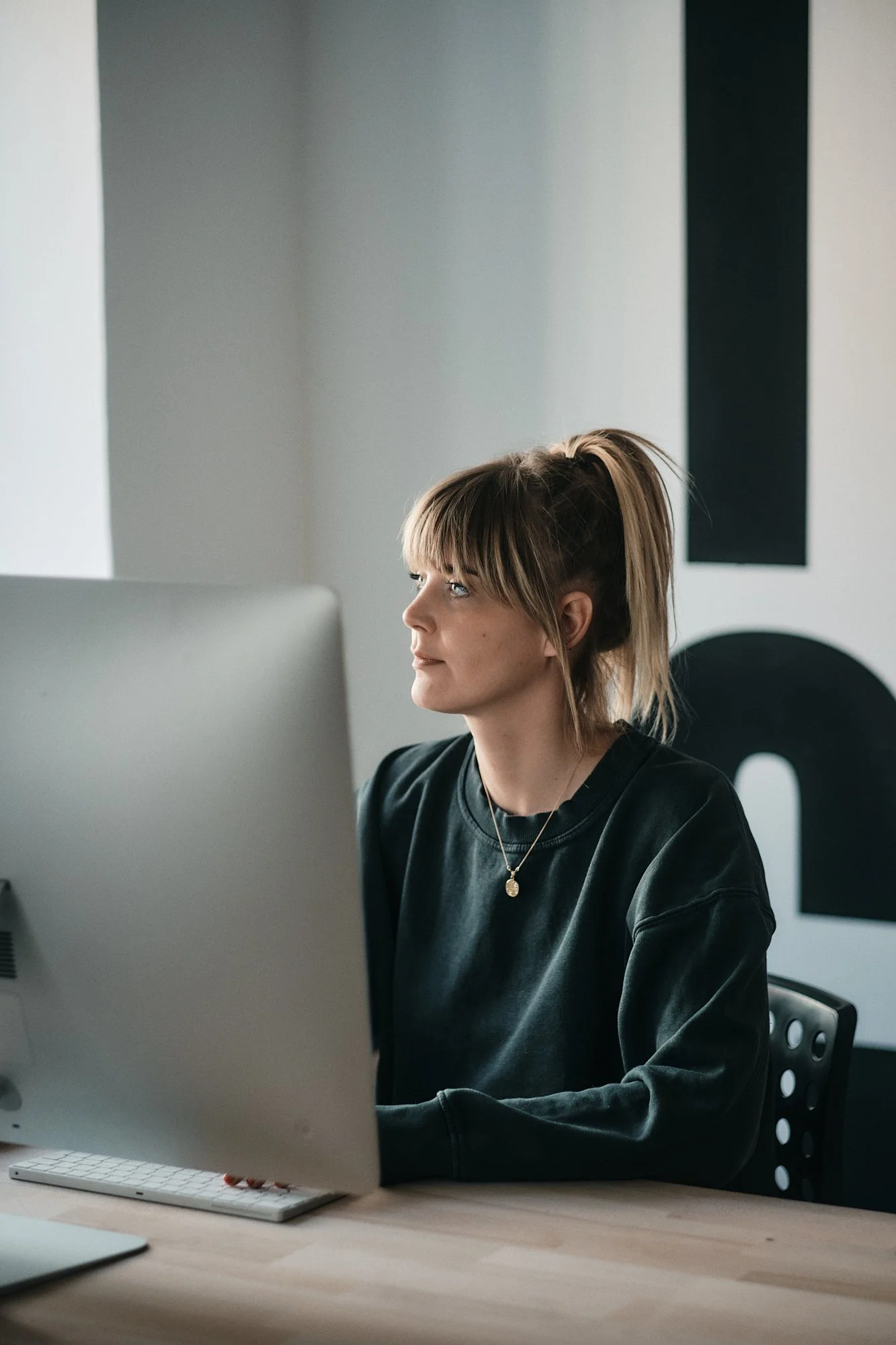 Junge Frau arbeitet an einem Computer im modernen Büro.