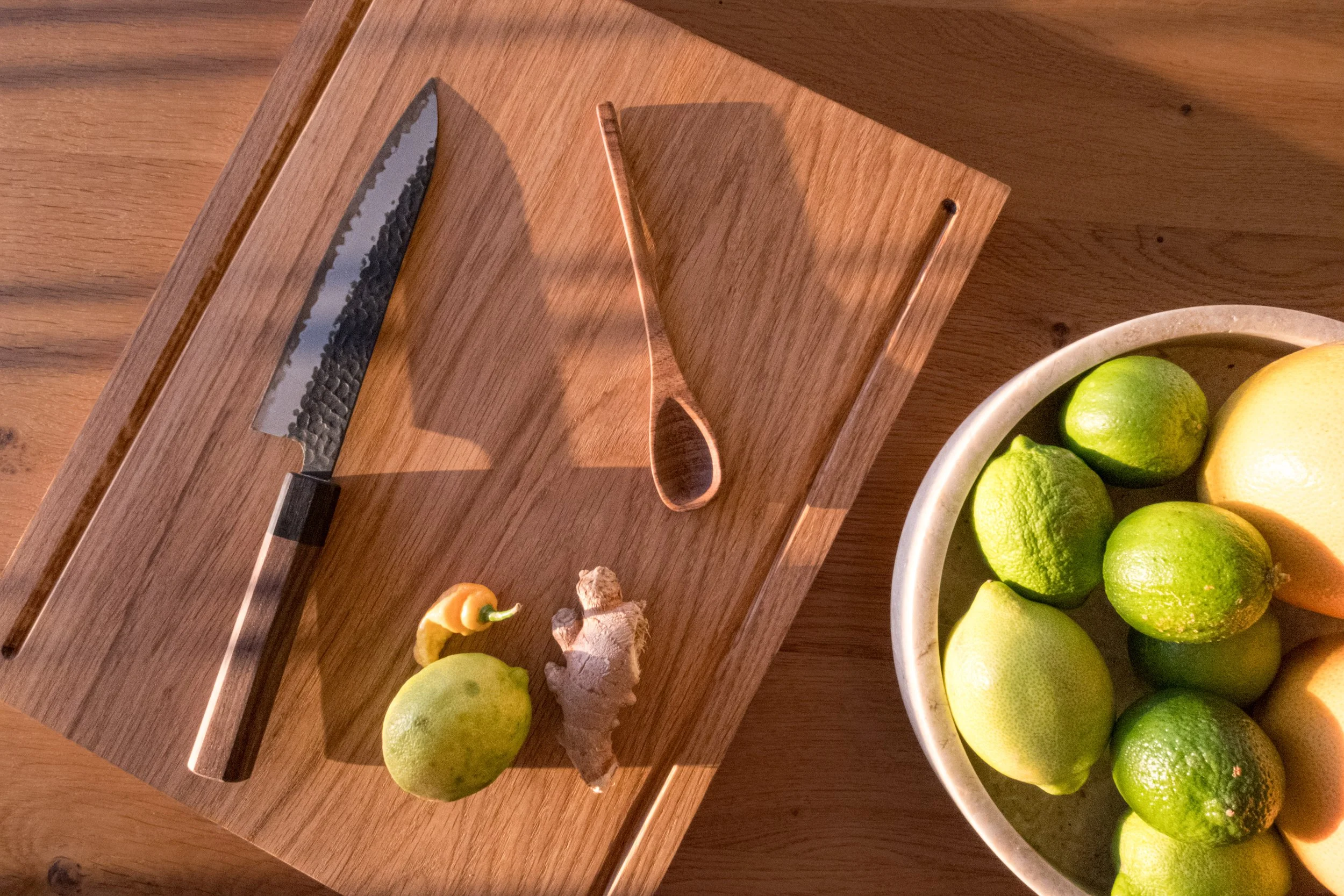 Handcrafted minimalist oak cutting board with a natural finish, two grooves and clean design.
