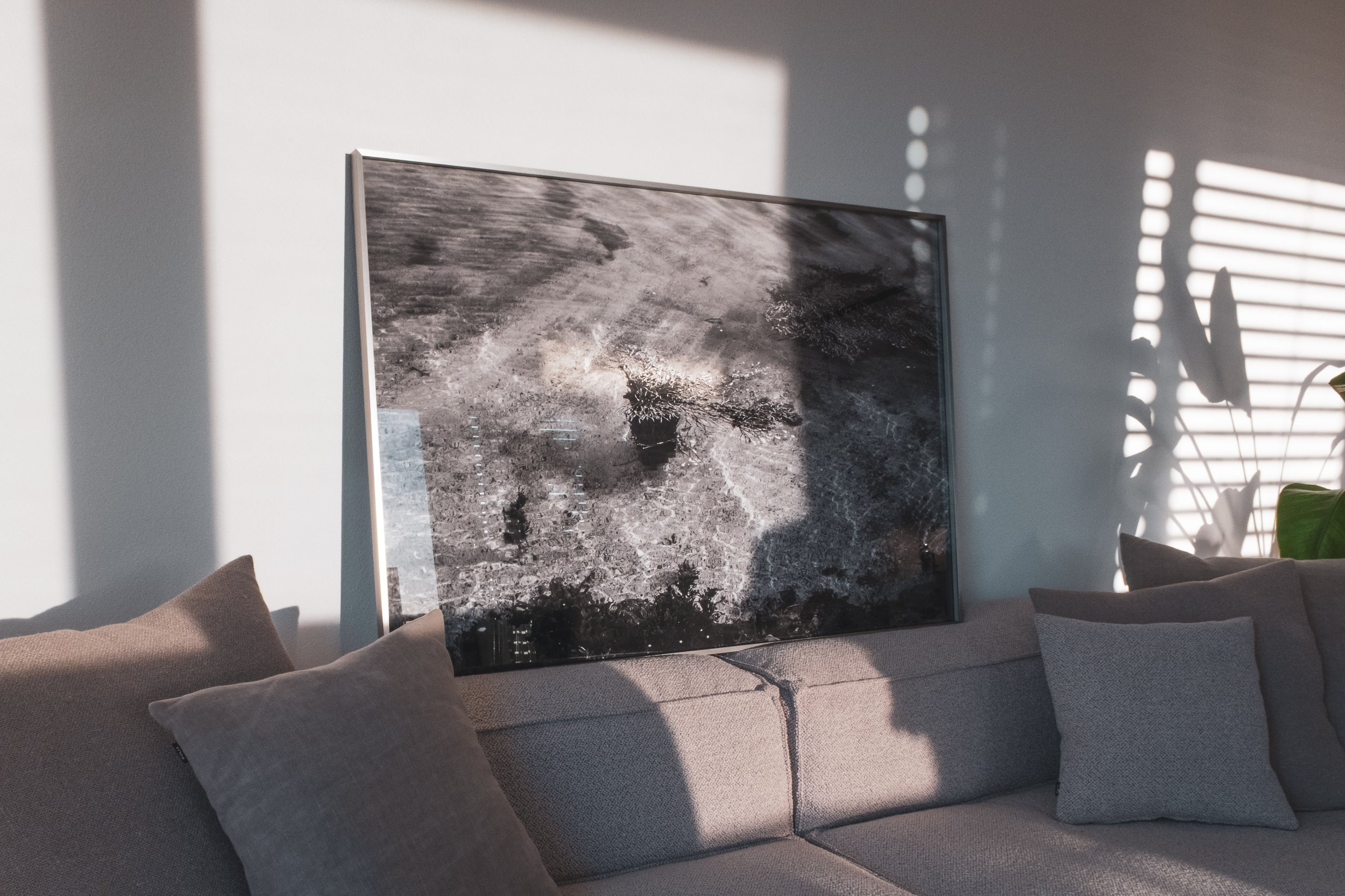 Black and white photograph in minimalistic aluminium frame in living room.