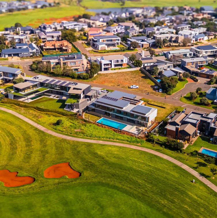 Aerial view of a residential neighborhood next to a golf course with two small sand traps.