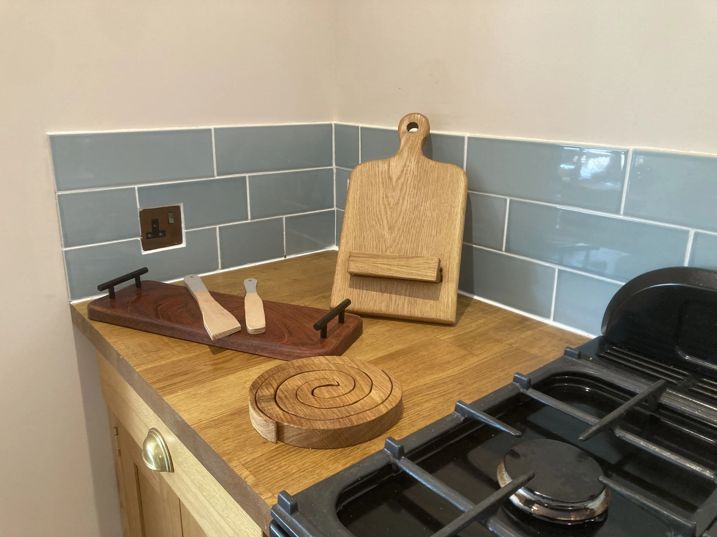 Kitchen countertop with various wooden cutting boards and a stove with black grates.