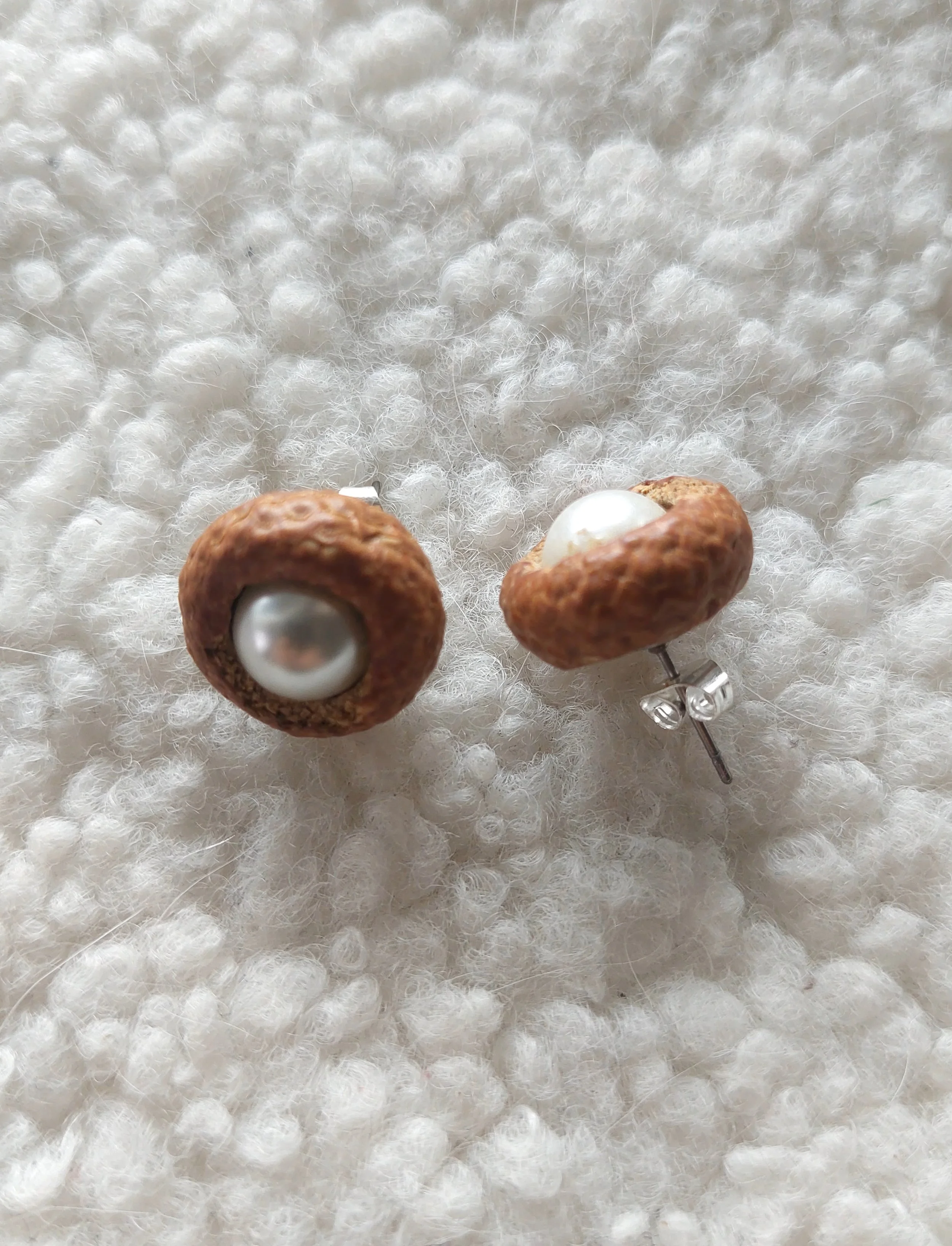 Paire de boucles d'oreilles perles nacrées dans son nid.