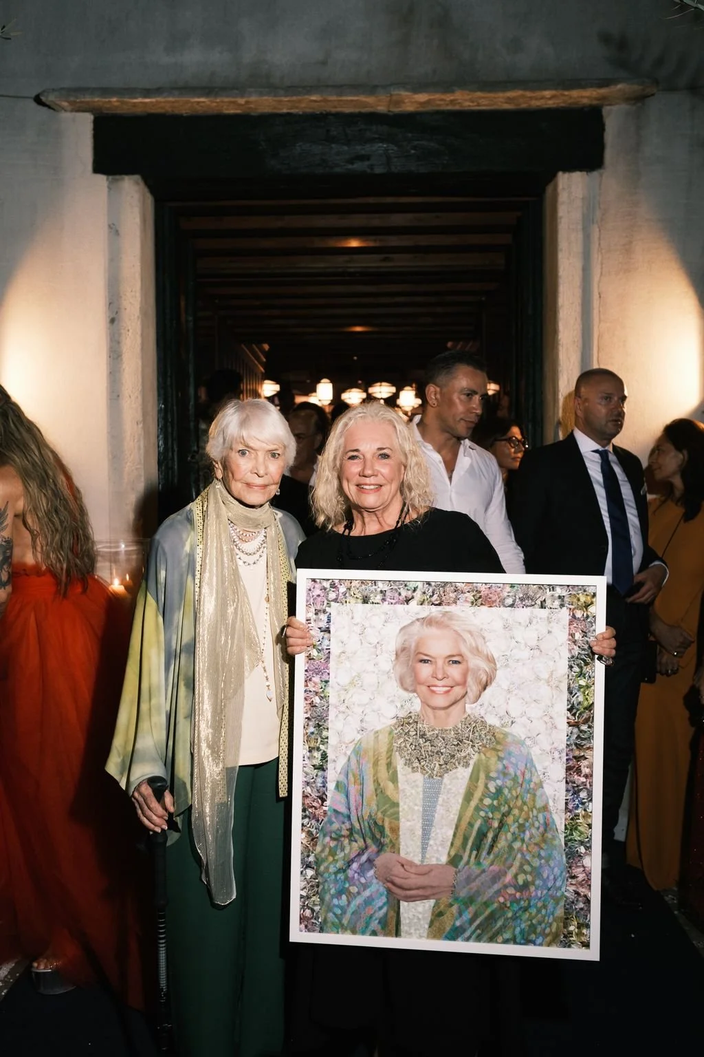 Ellen Burstyn and Myra Fiori holding the layered-jewelry portrait of Burstyn commissioned by Liberatum, Venice, September 2024
