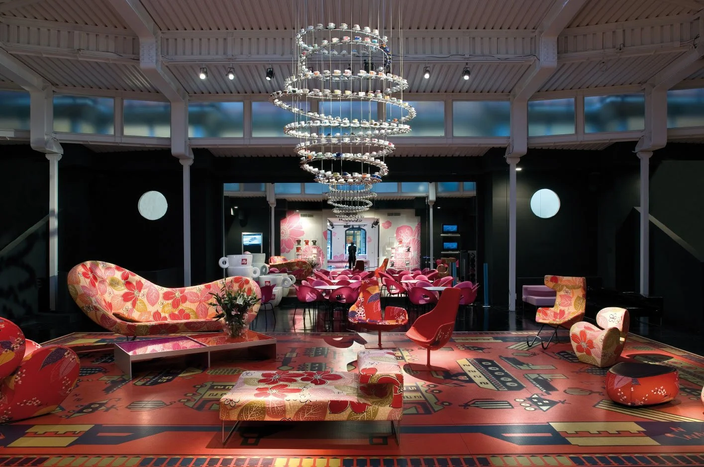 Galleria Illy, Milan: pop-up cultural space created by Myra Fiori for illy, with a spiral chandelier of coffee cups and floral-patterned seating