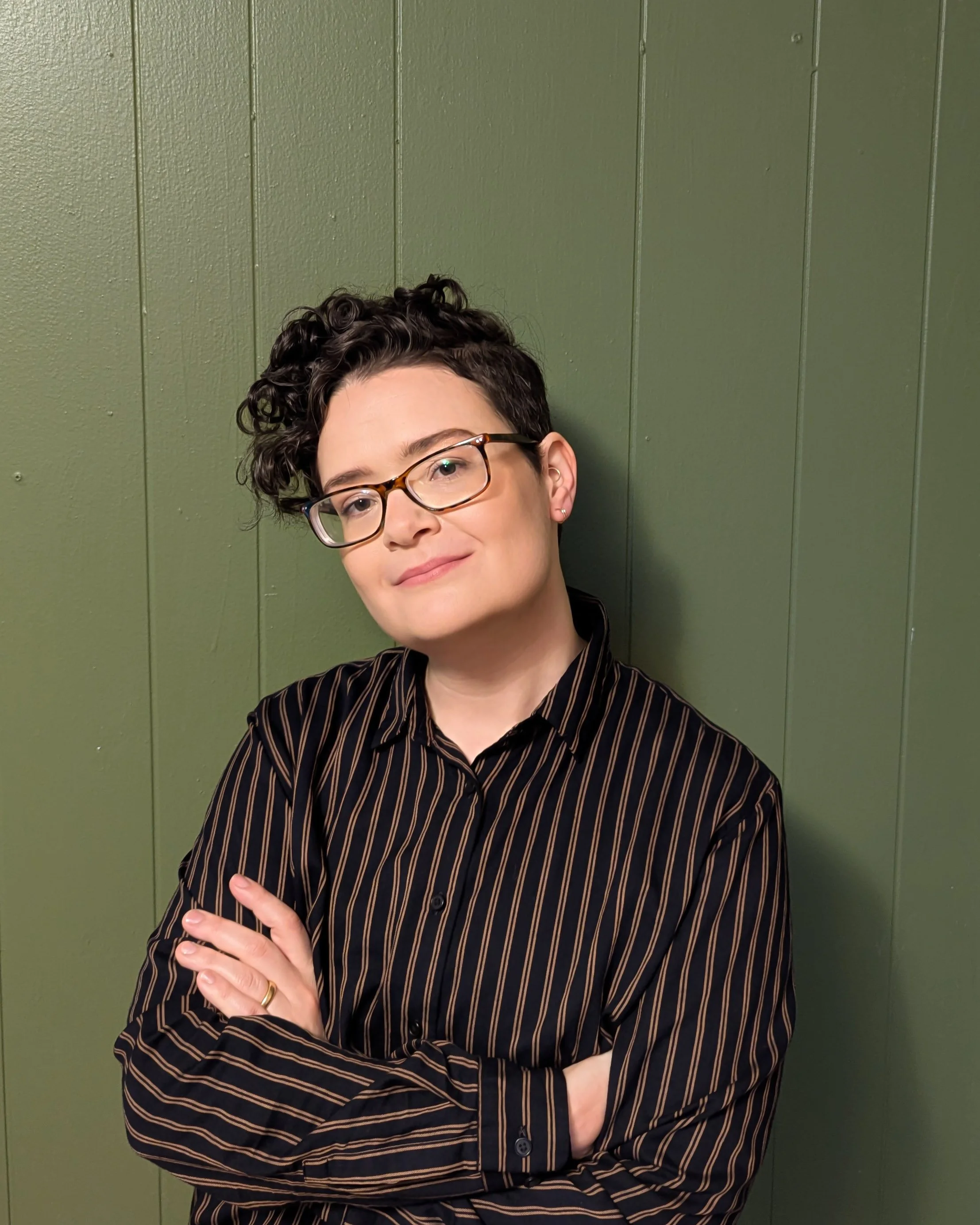 A nonbinary person with short curly hair and glasses | Virtual ADHD therapy in Massachusetts