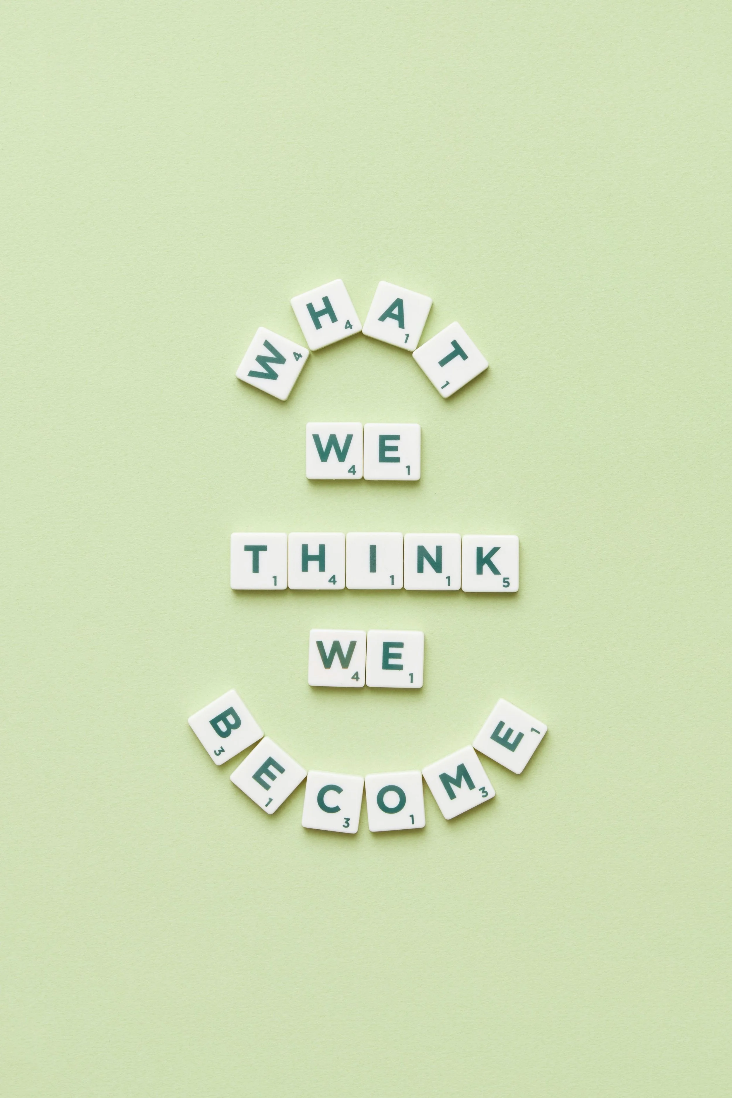 An image of scrabble tiles which spell out "what we think we become."