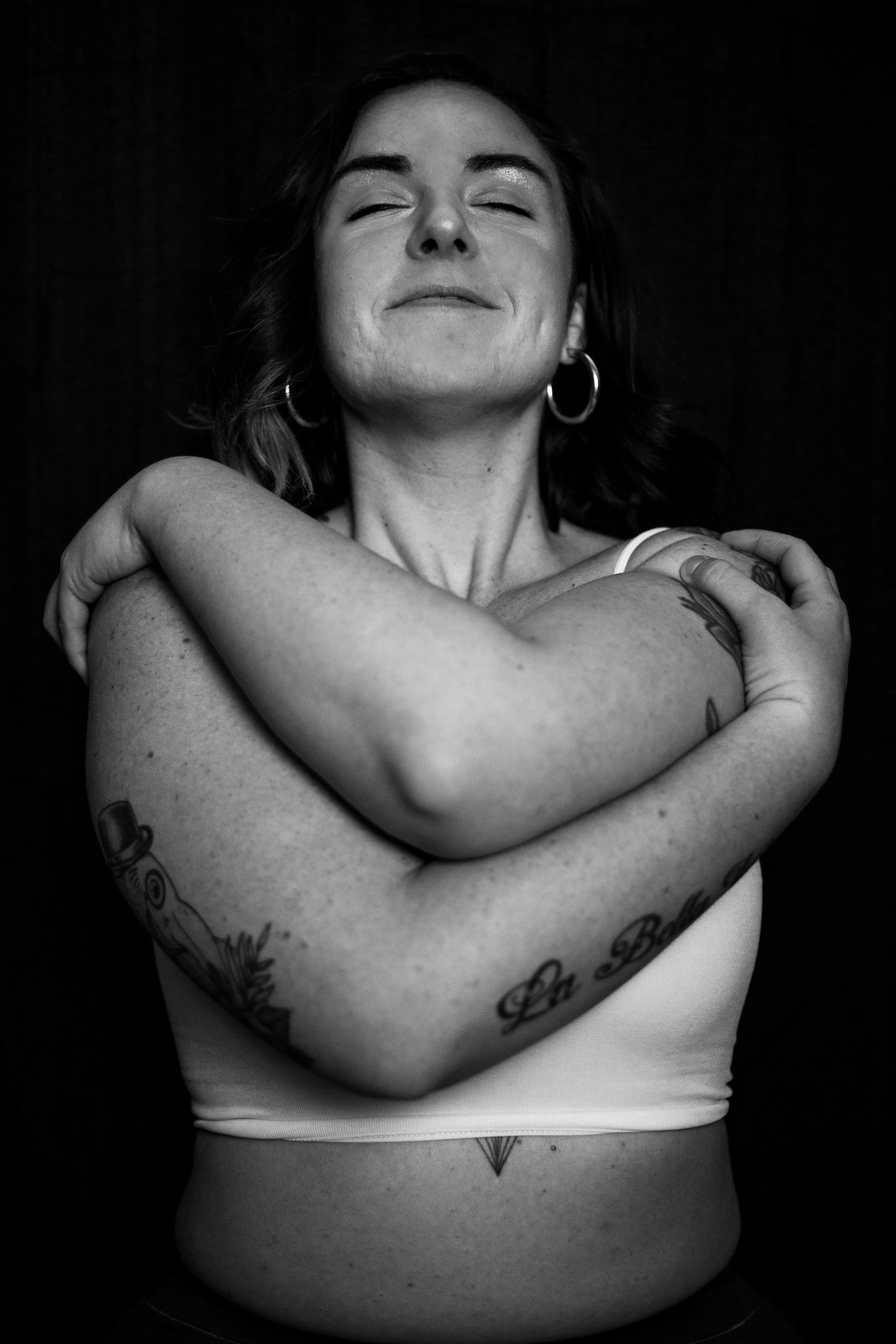 A smiling, calm person with their arms crossed over their body | Virtual EMDR therapy in Massachusetts