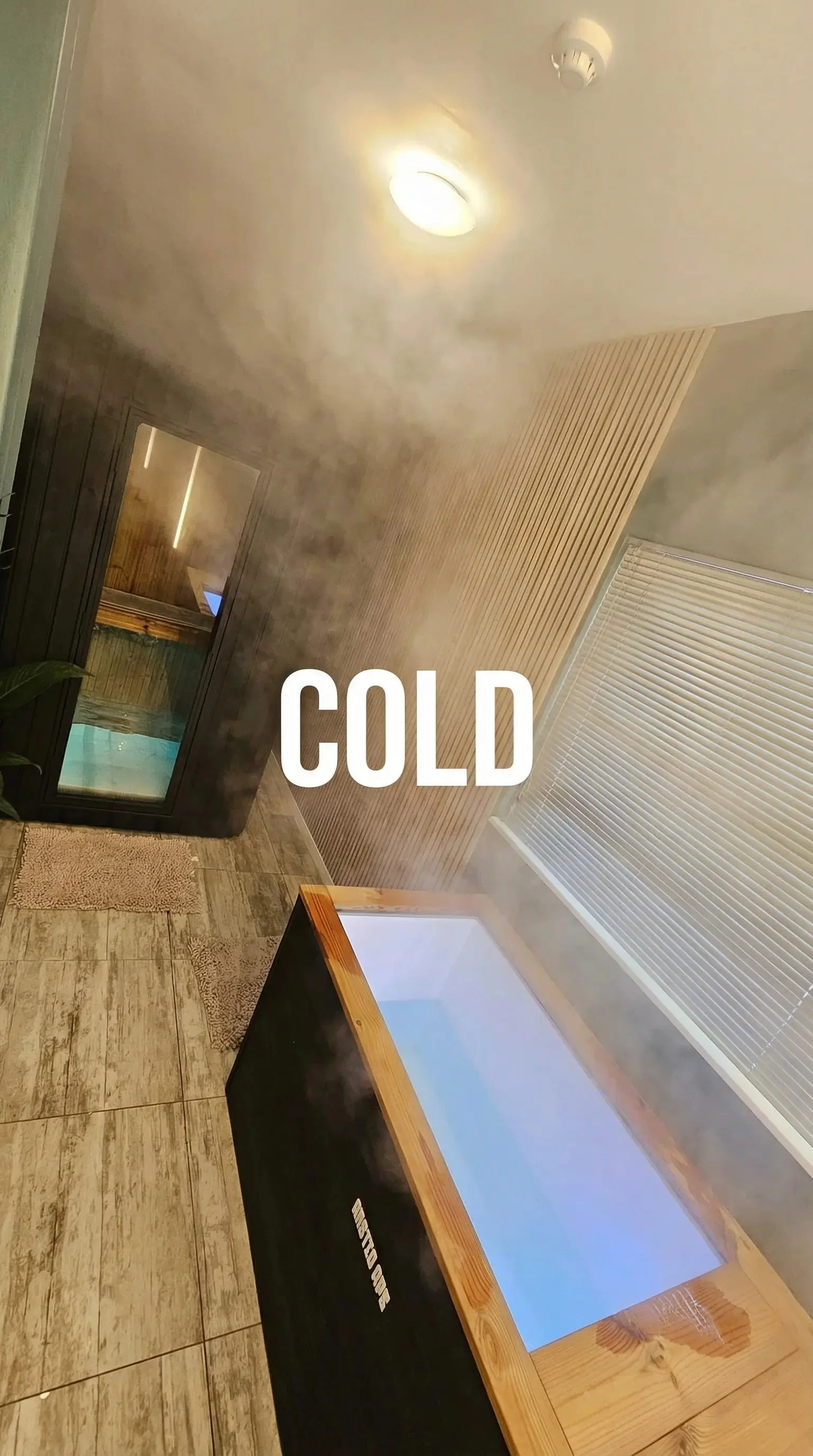 A room with a mountain of steam or fog, a fireplace, a window with blinds, and a TV on a wooden stand, with the word 'COLD' written on the image.