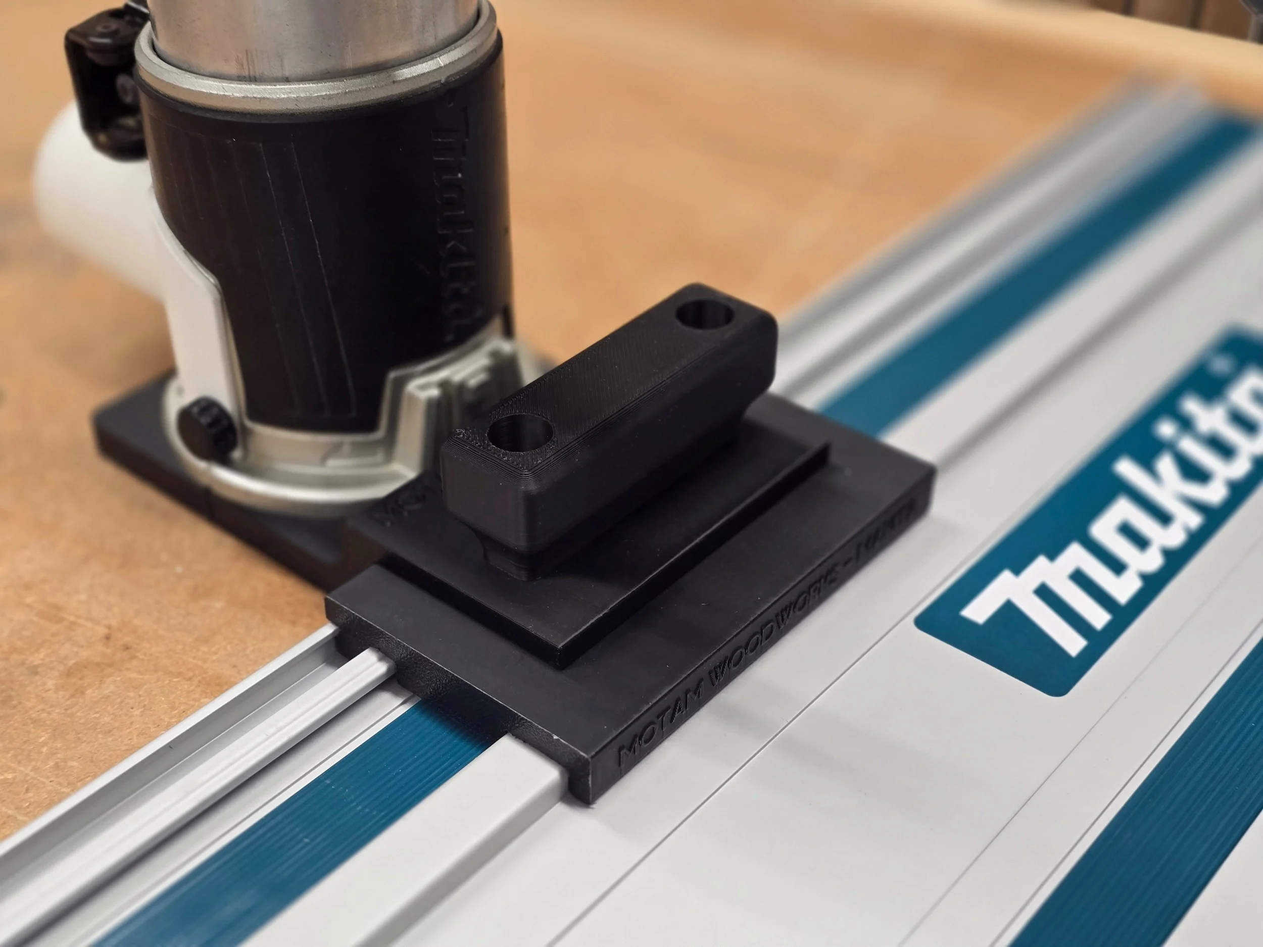 Makita compact router with the Motam Woodworks base and handle, resting on a Makita guide rail