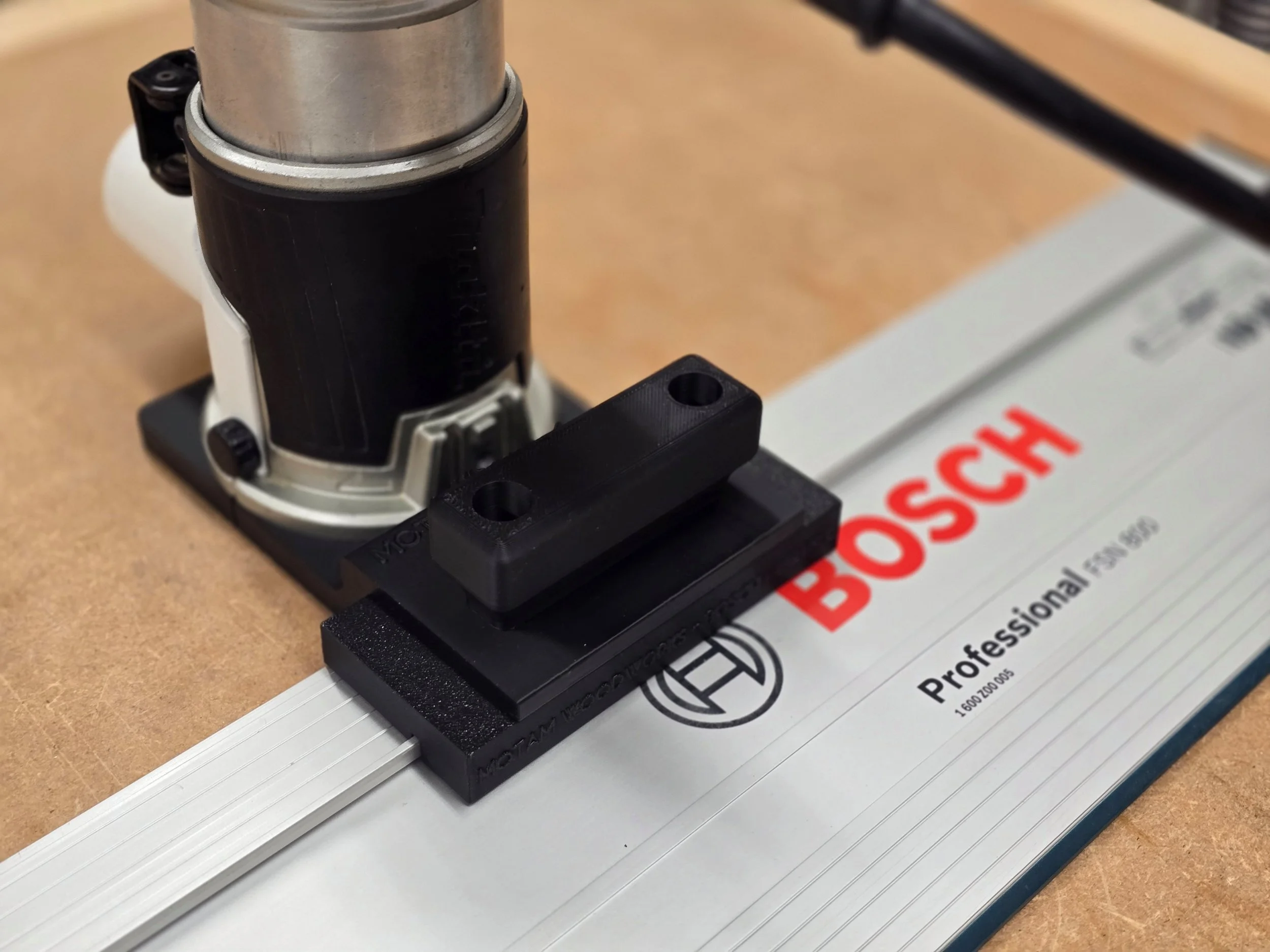 Makita compact router with the Motam Woodworks base and handle, resting on a Bosch guide rail