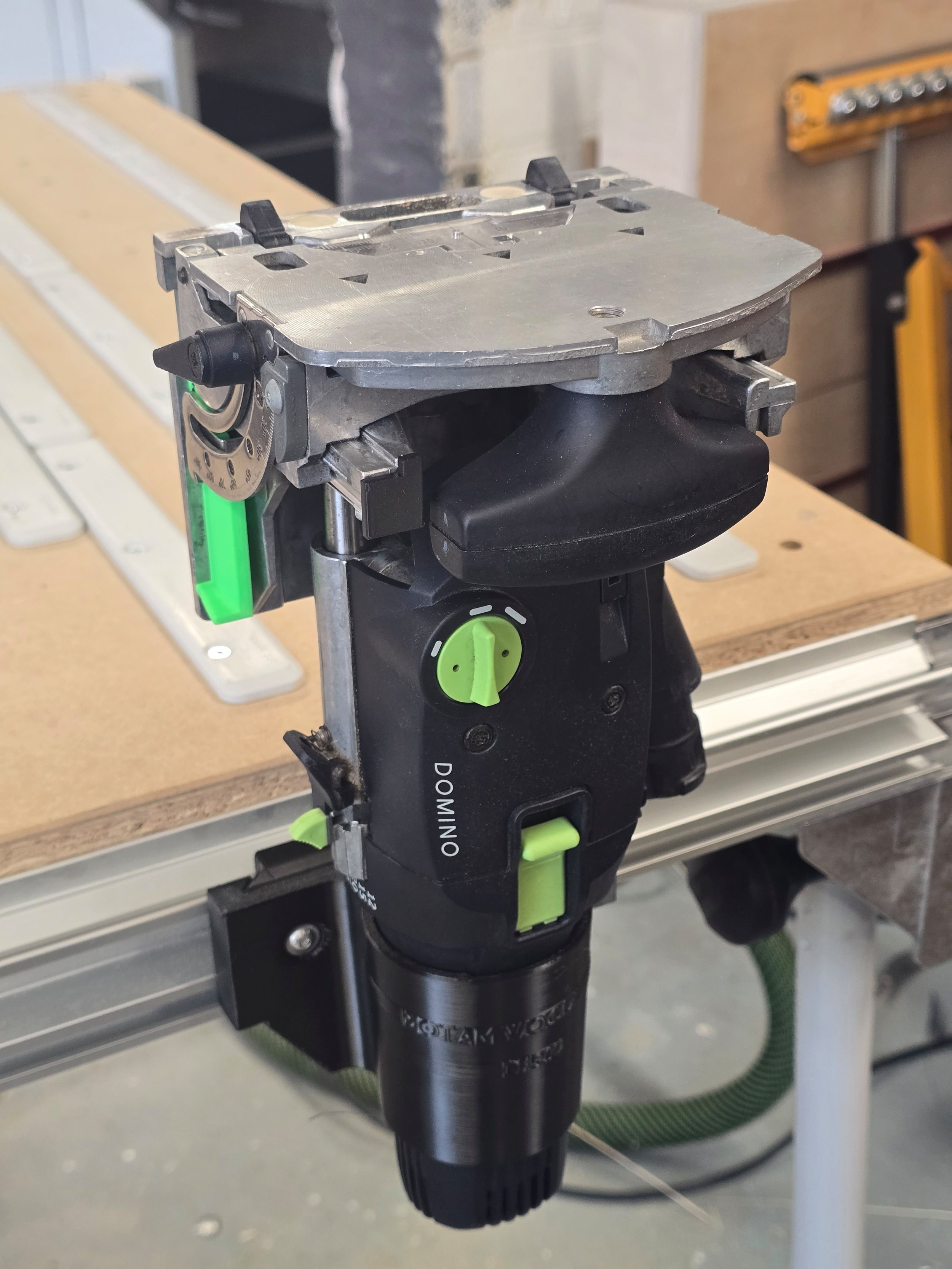 A Festool Domino DF500 held in its mount, embossed "Motam Woodworks DF500," fitted to an MFT table