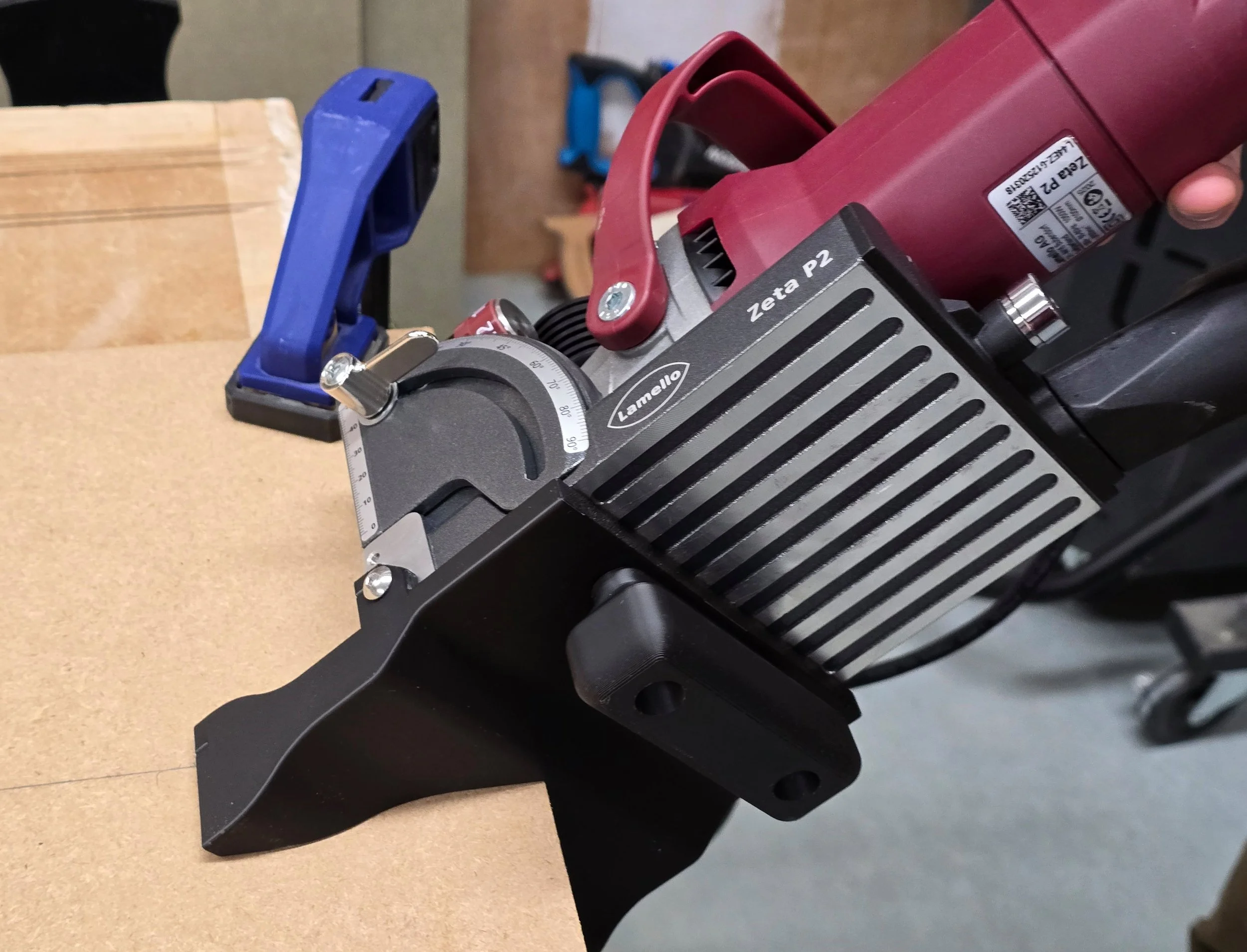 The spline jig fitted to a Lamello Zeta P2, positioned against the corner edge of an MDF board ready to cut