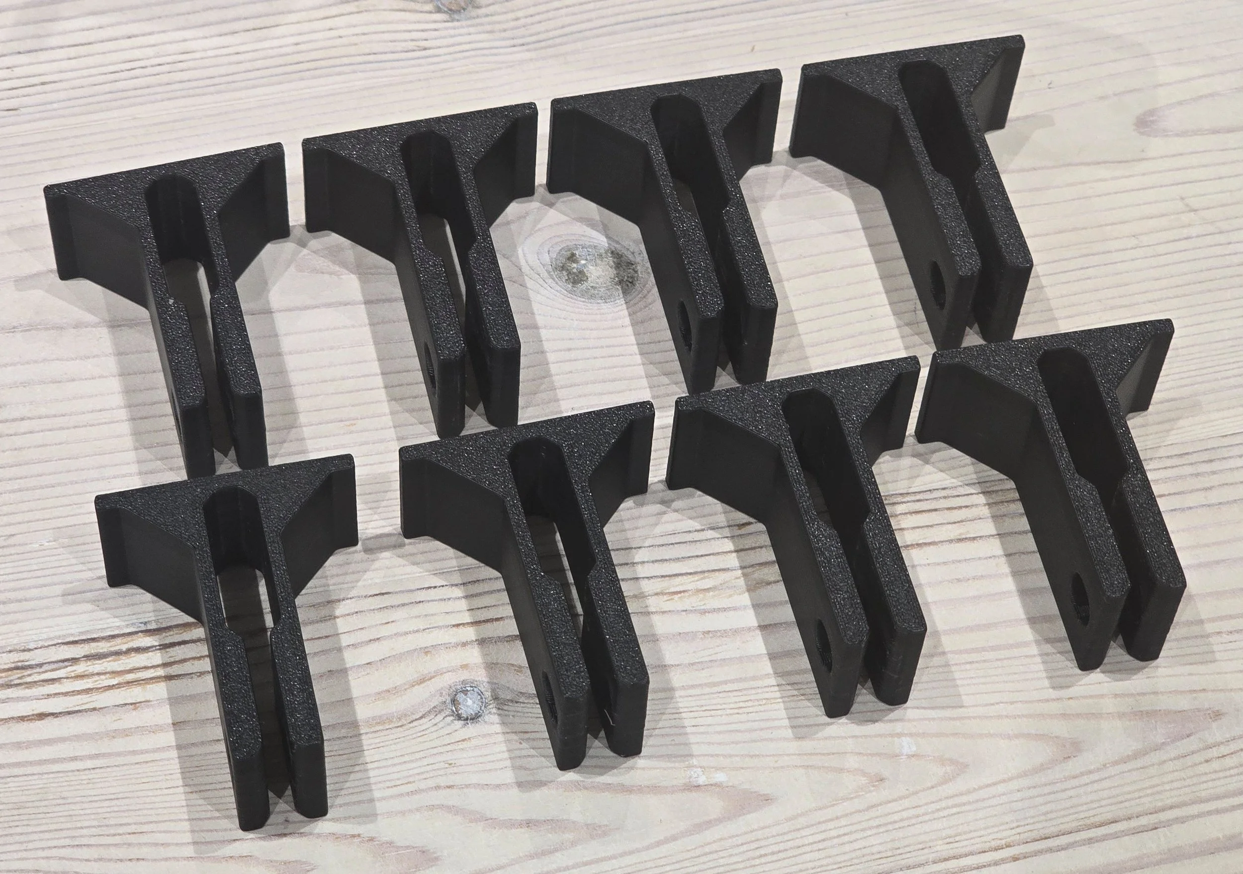 Eight bar protection clips laid out separately on a workbench