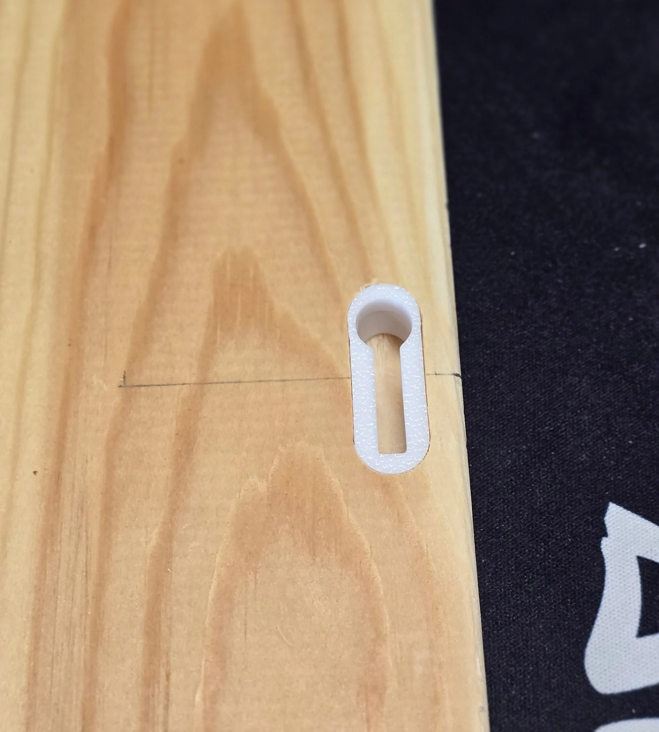 A keyhole bracket inserted into a Domino slot cut into the edge of a wood board