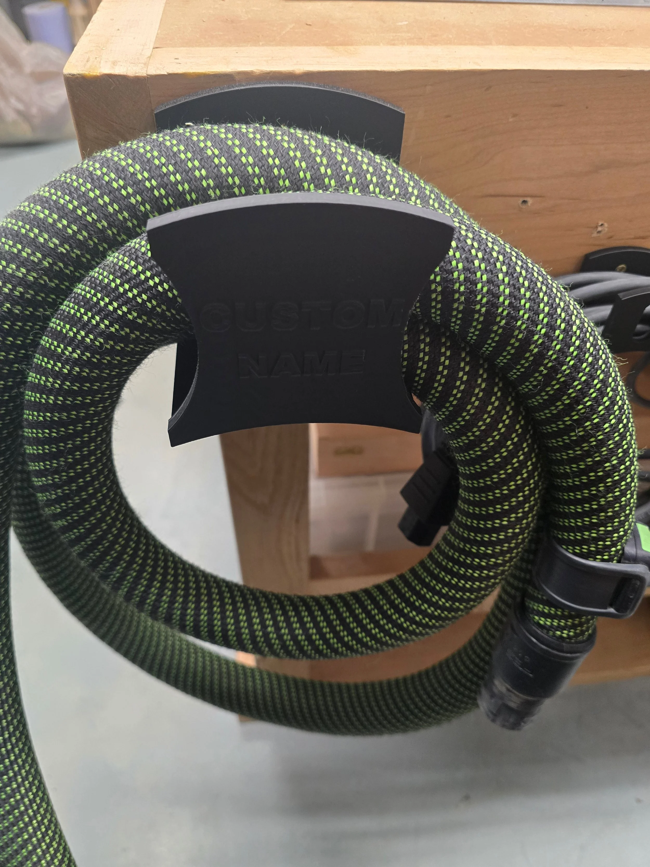 An unmounted wall mount bracket embossed "Motam Woodworks" and "Festool 27mm Hose"