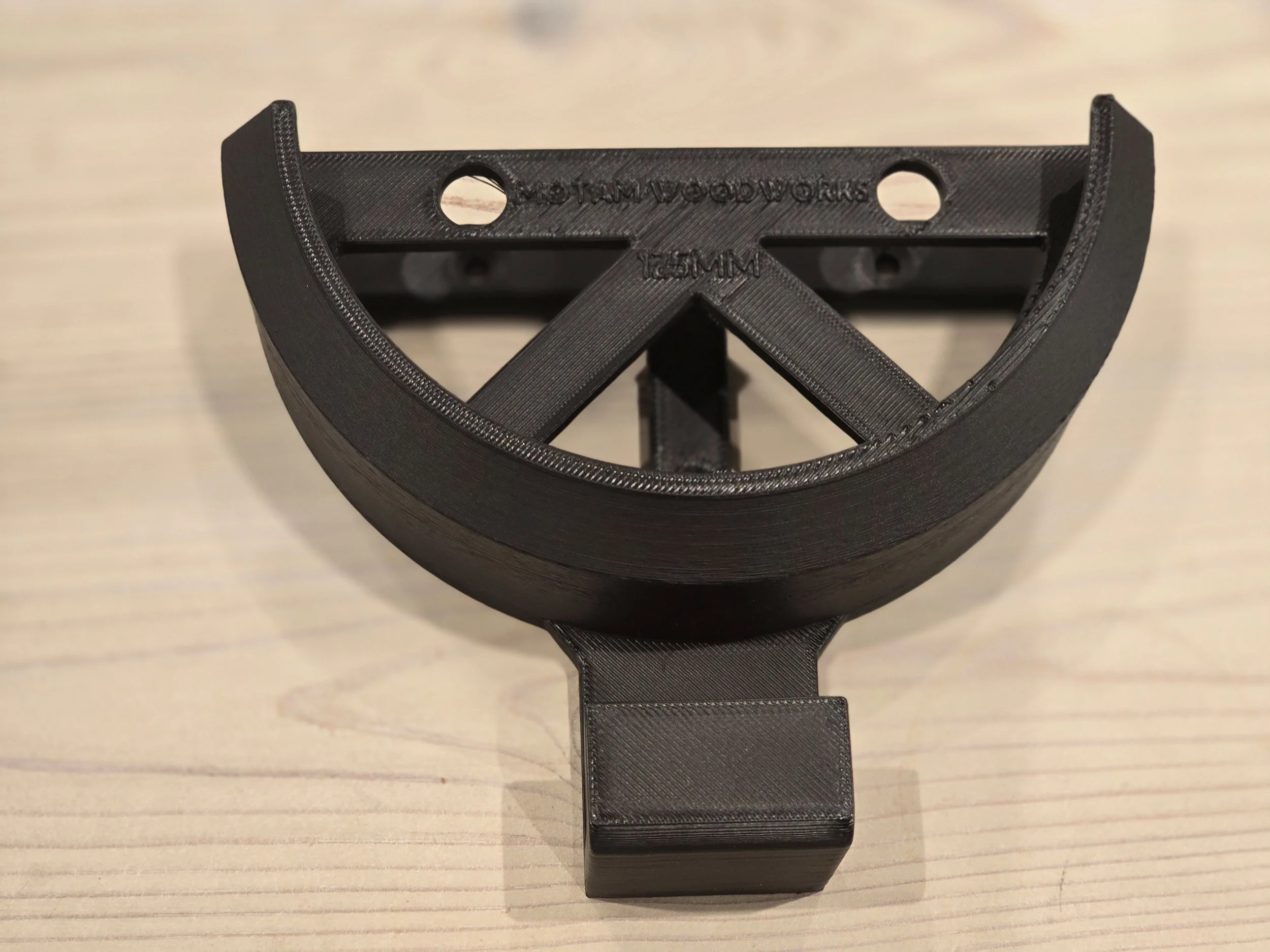 An empty 125mm wall mount bracket with an integrated cable hook, embossed "Motam Woodworks 125mm"
