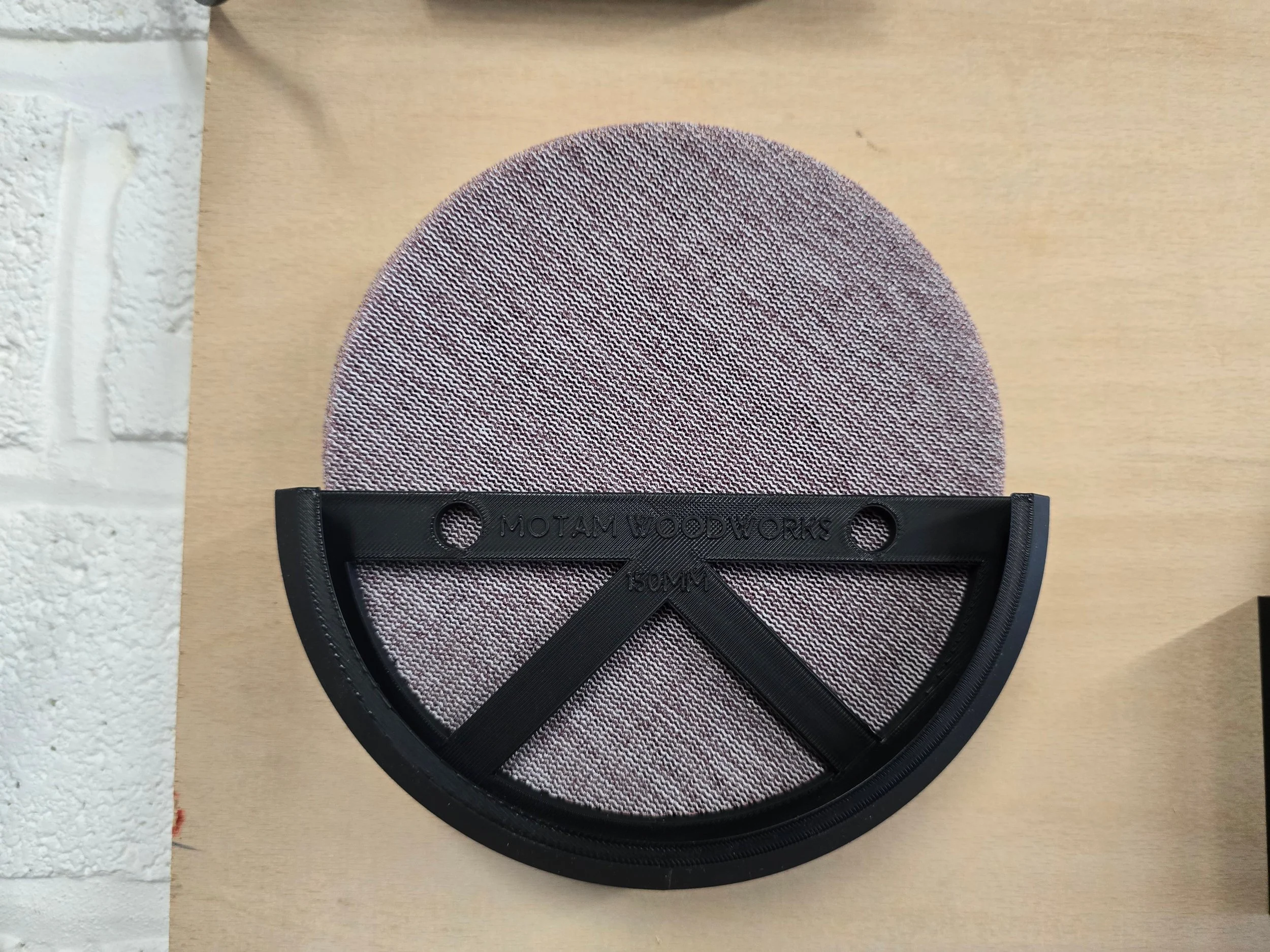 The 150mm wall mount bracket holding a stack of sanding discs