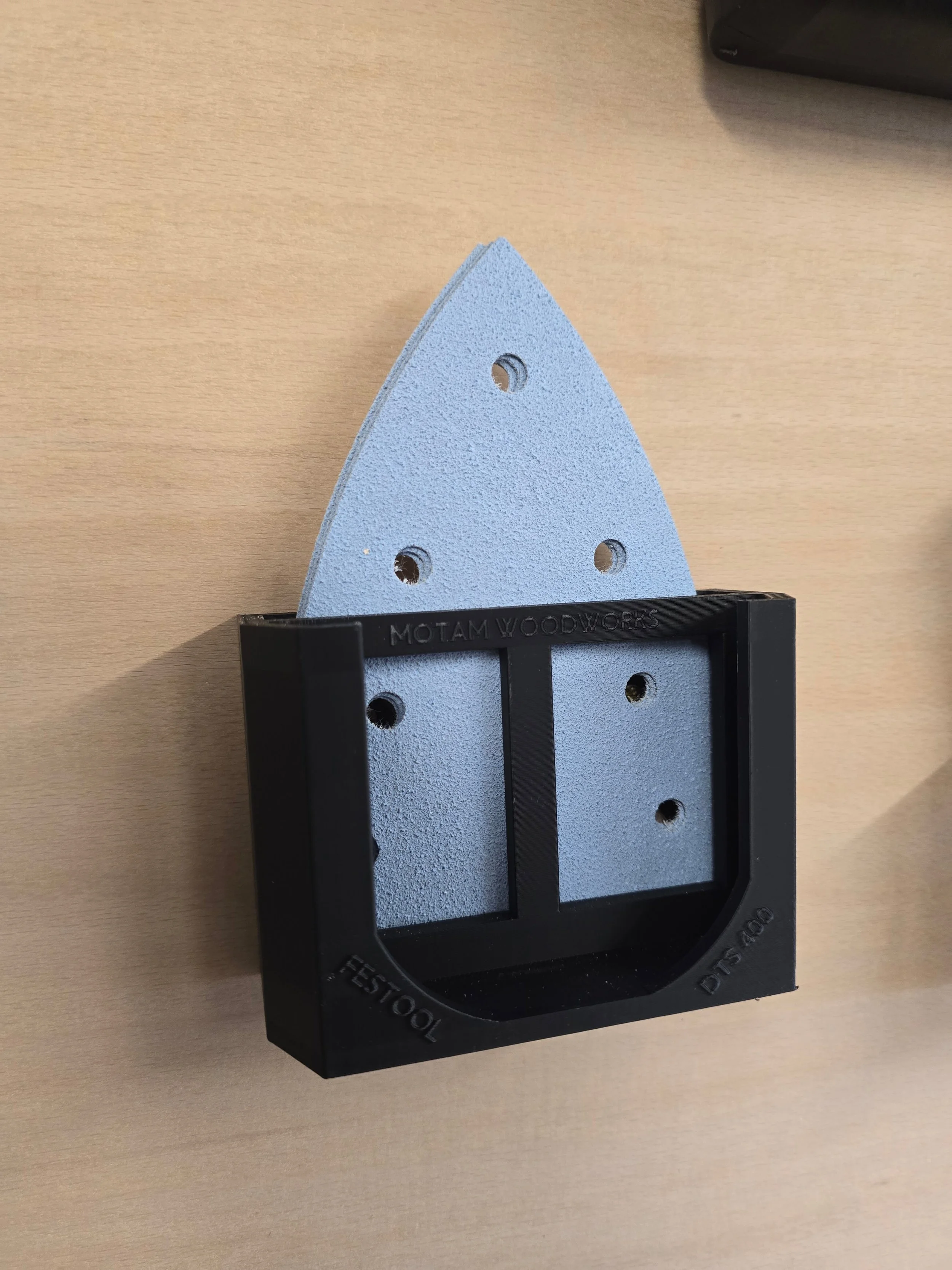 The Festool DTS 400 bracket holding a stack of delta-shaped sanding pads