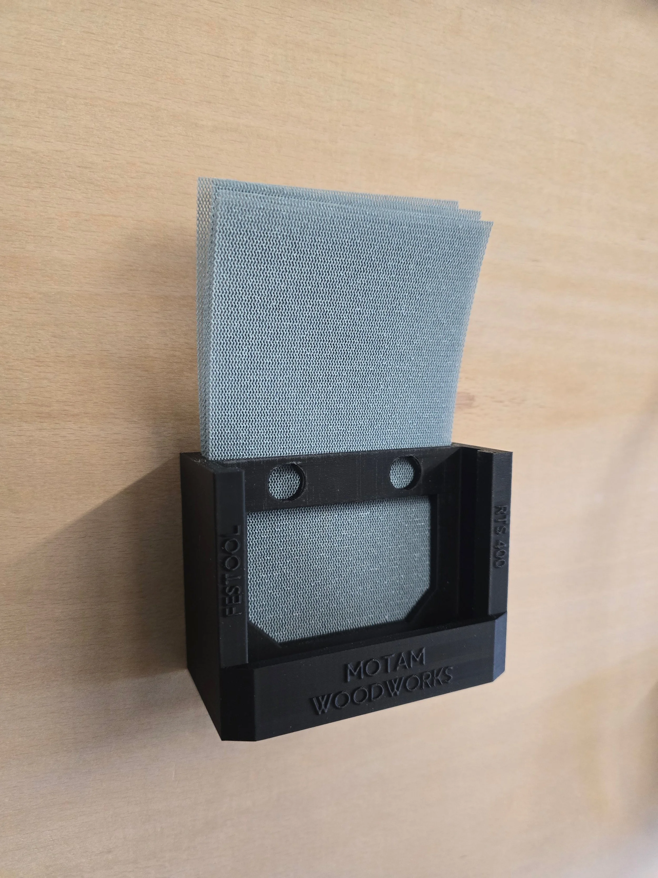 The Festool RTS 400 bracket holding a stack of rectangular sanding sheets