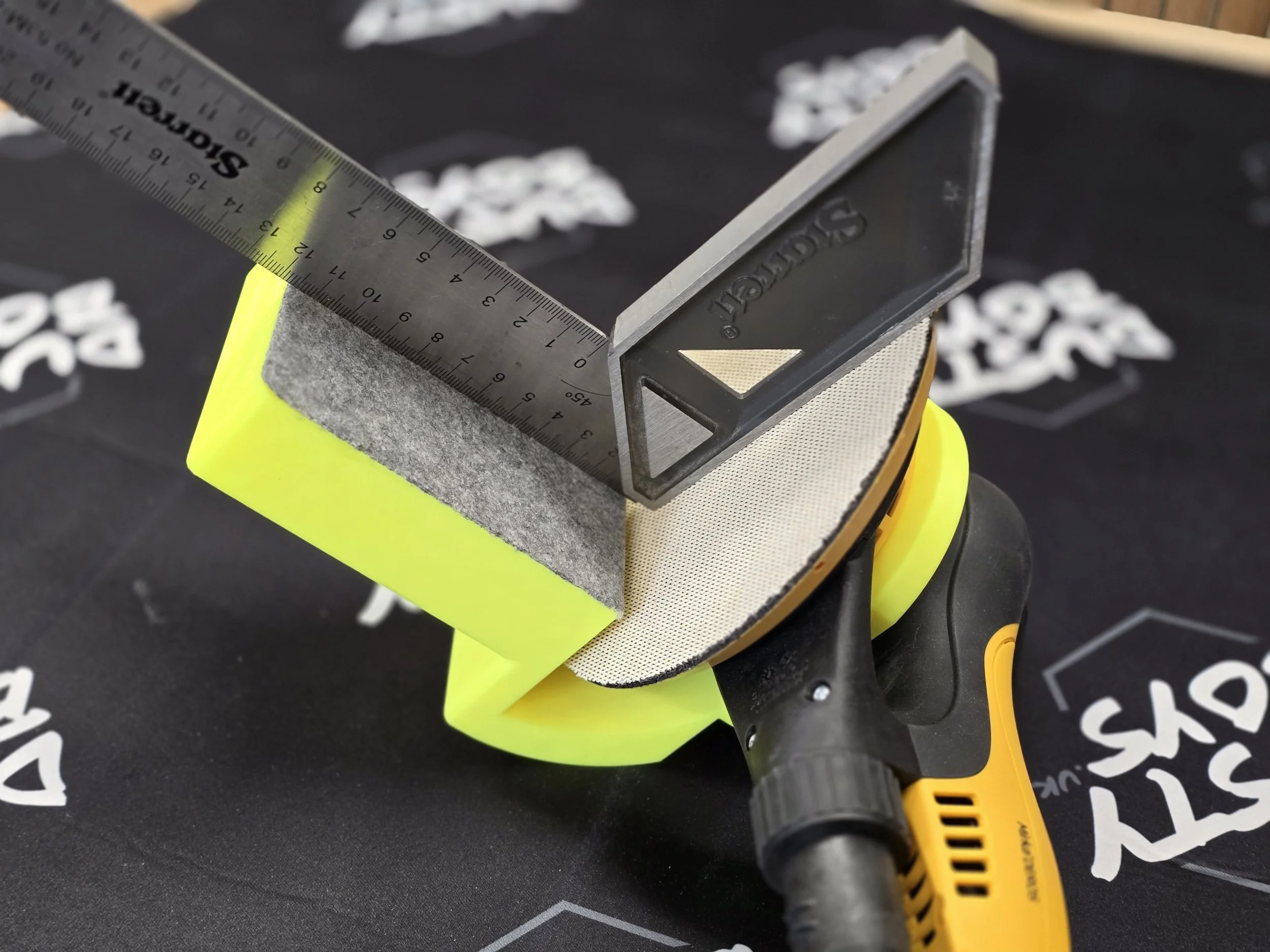 A Starrett engineer's square checking the guide's 90-degree accuracy on a Mirka sander with a round sanding pad