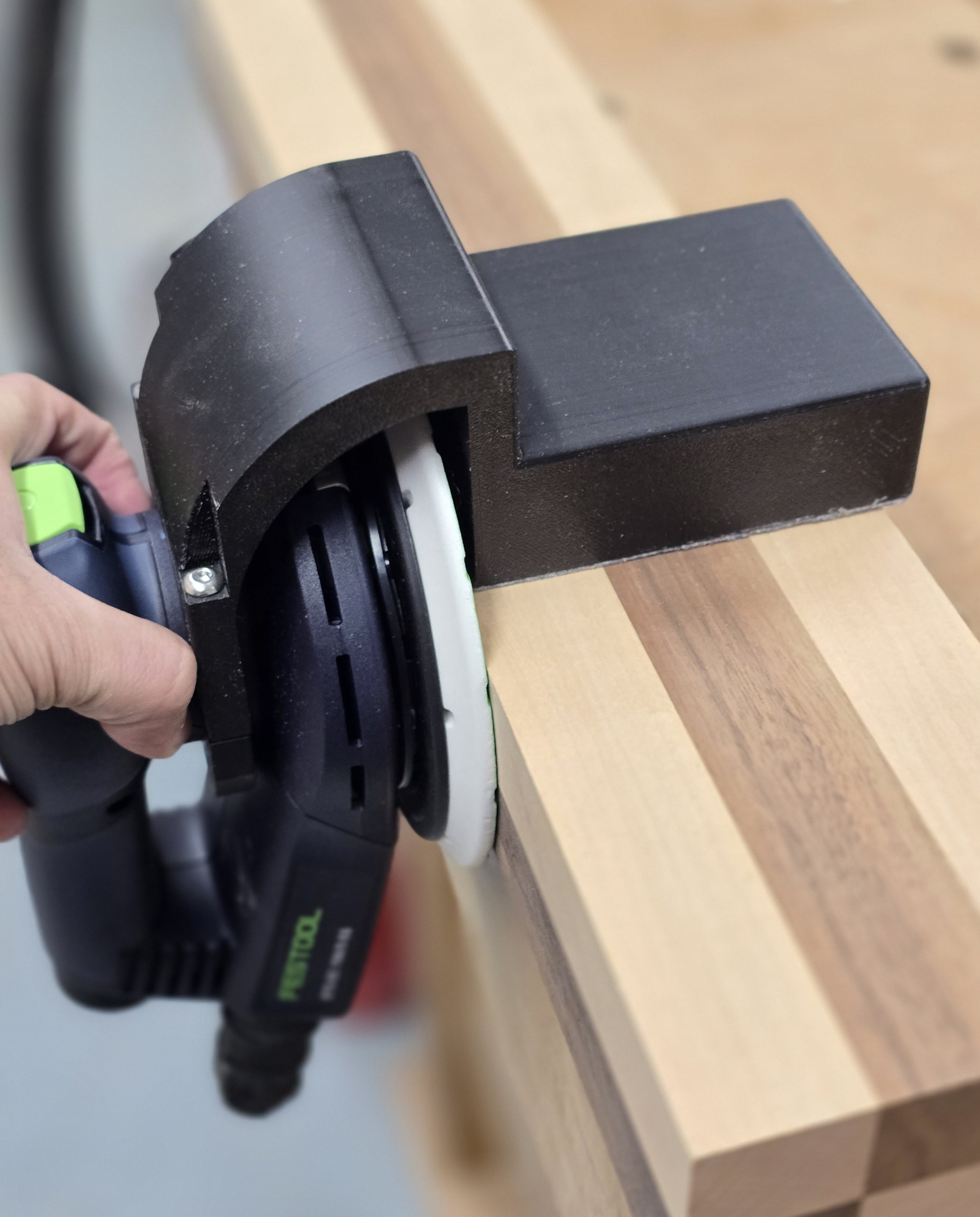 The Motam edge guide fitted to a Festool ETS EC sander, sanding the edge of a wooden board
