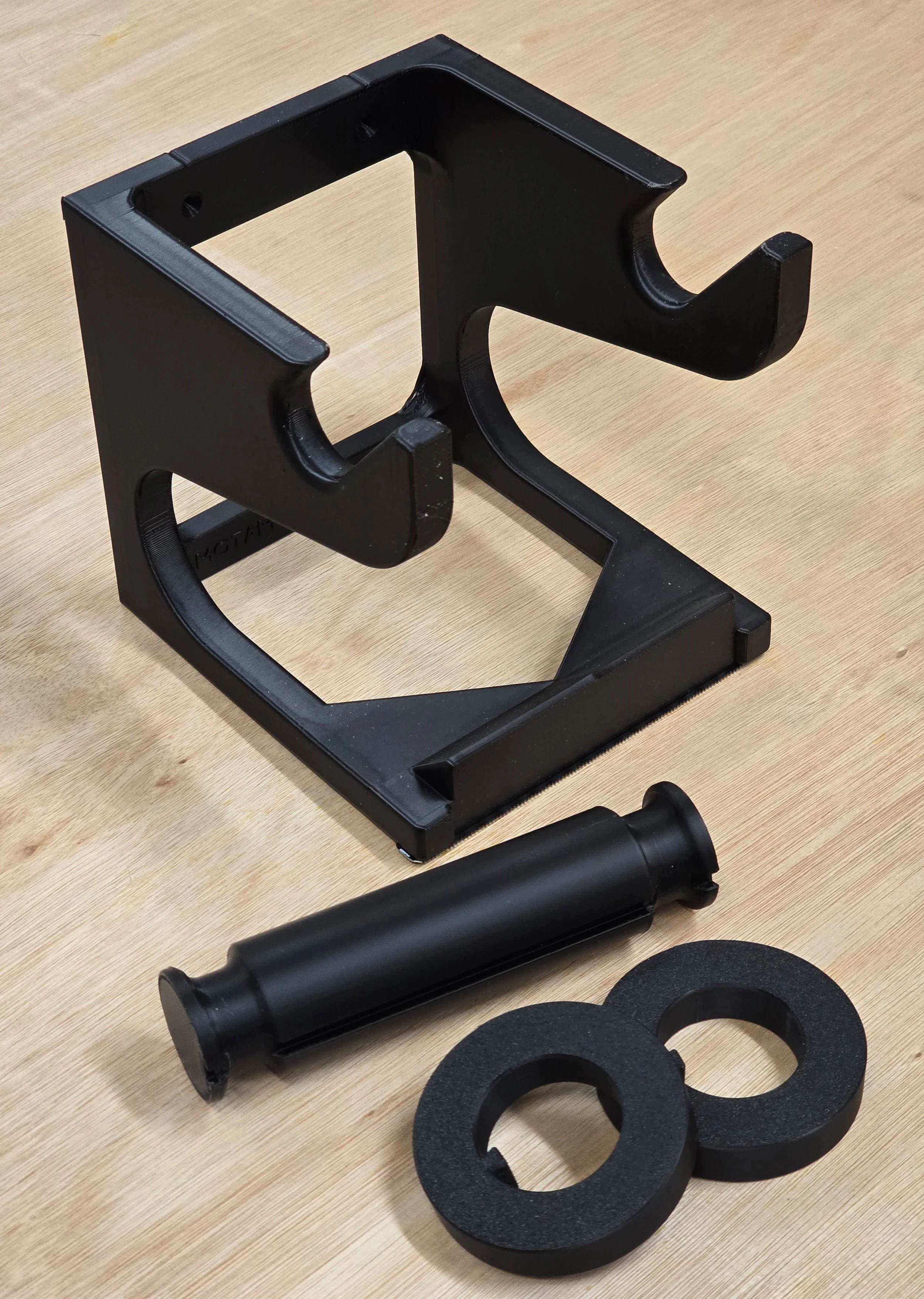 The full kit laid out — wall-mount bracket, roller spool, and two roller sleeves