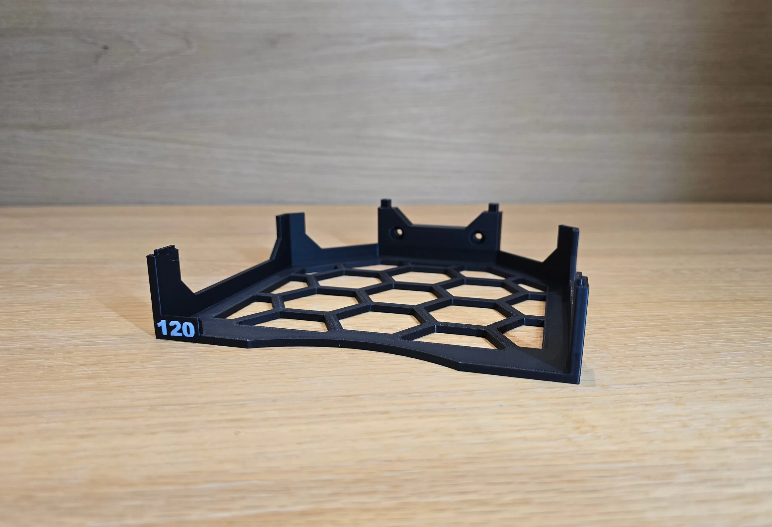 A single 120-grit tray from the sanding disc holder, showing the hexagonal lattice base and embossed grit label