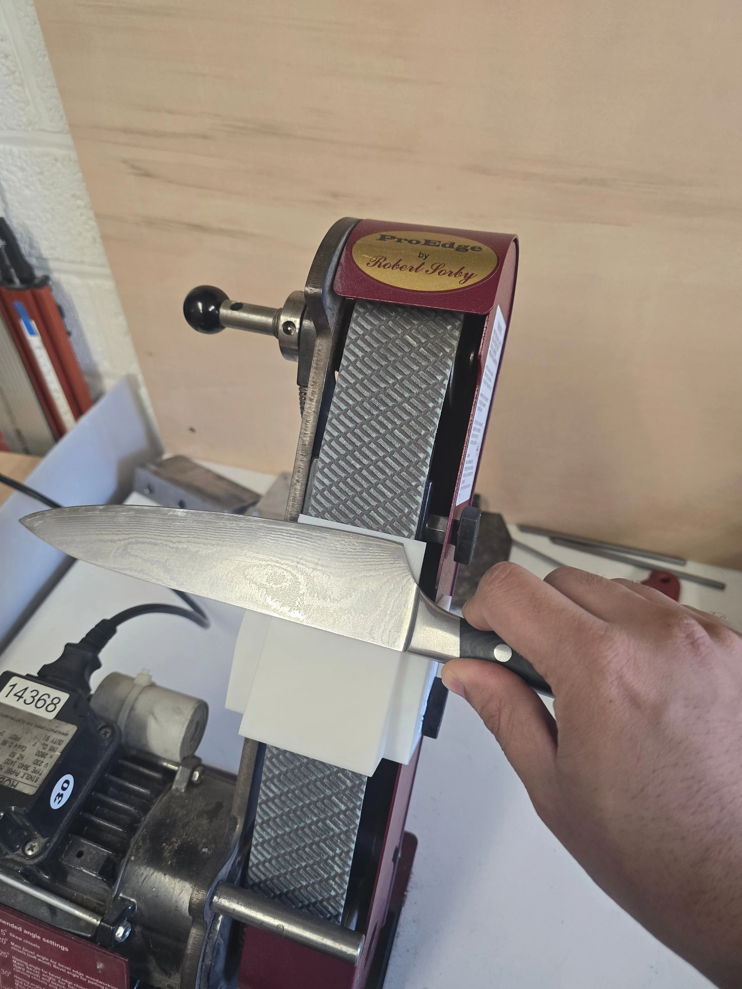 Motam Woodworks Standard knife sharpening jig mounted on the Robert Sorby ProEdge with a knife being sharpened
