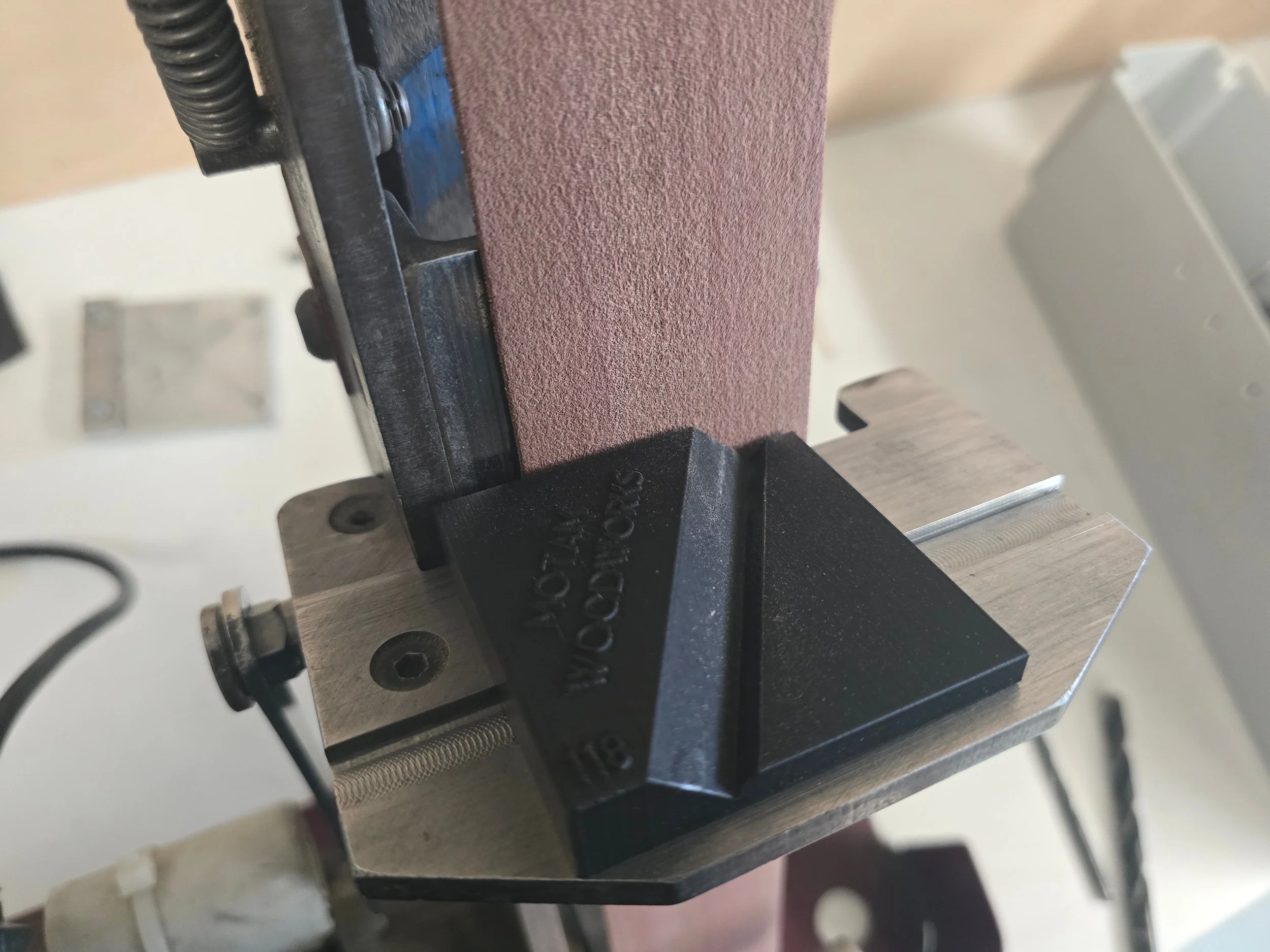 Close-up of the Motam woodworks drill bit jig mounted on the ProEdge system, showing its angled guide face