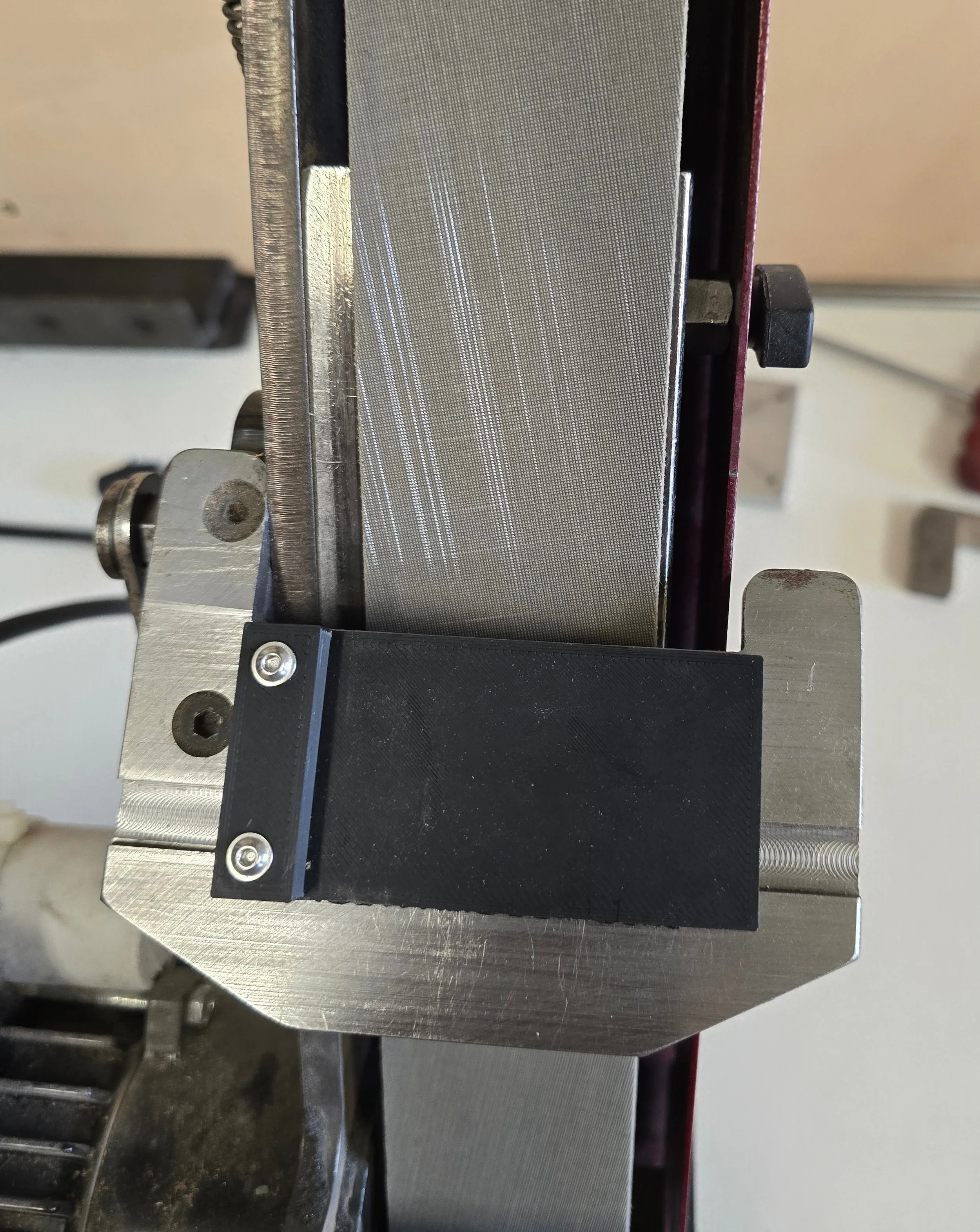 Close-up of the square guide jig mounted on the ProEdge machine from a different angle, showing the fit against the backplate
