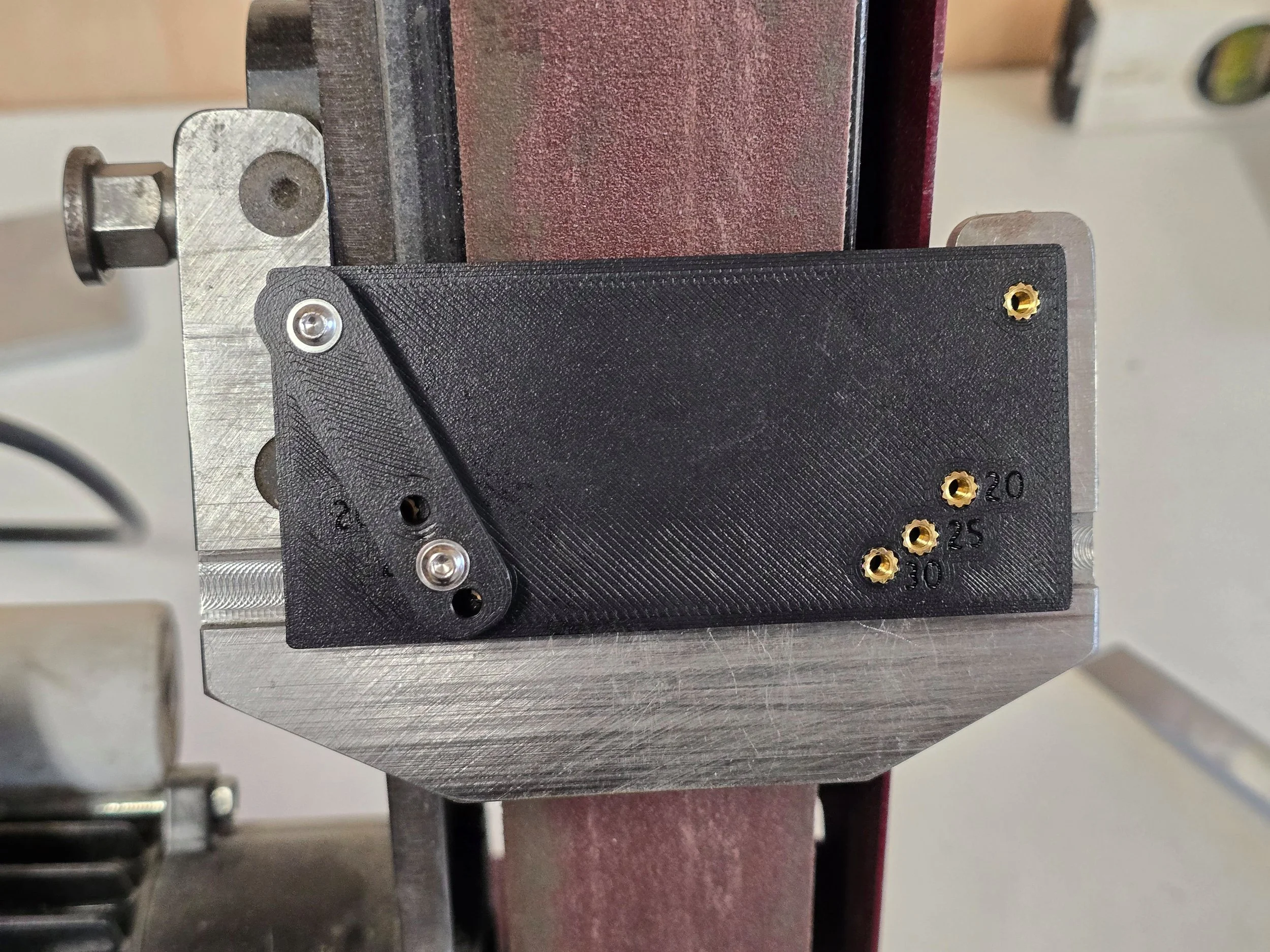Close-up of the Motam skew chisel jig mounted on the Robert Sorby ProEdge system, showing the 20°, 25°, and 30° angle-setting points
