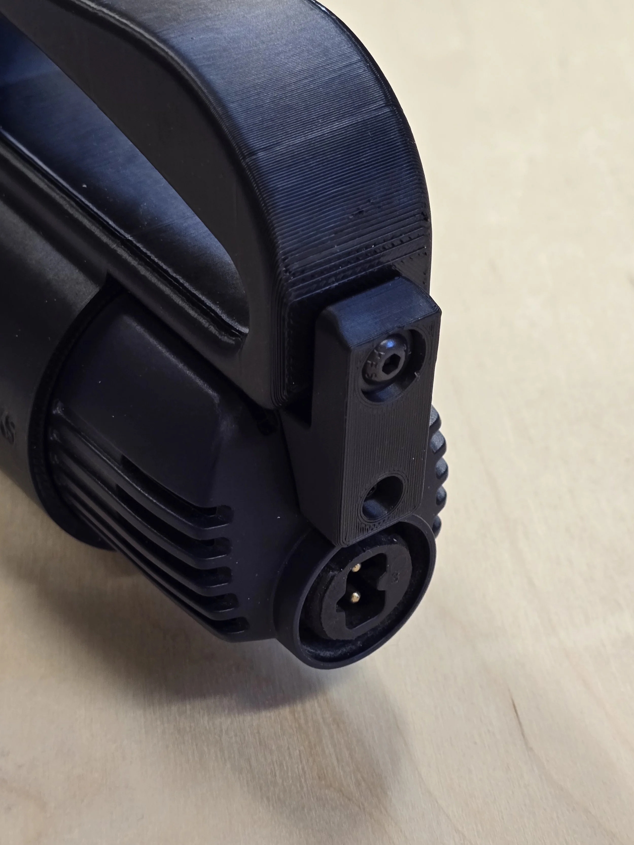 Close-up of the D-Handle's optional locking bracket fitted at the base, showing the locking screw