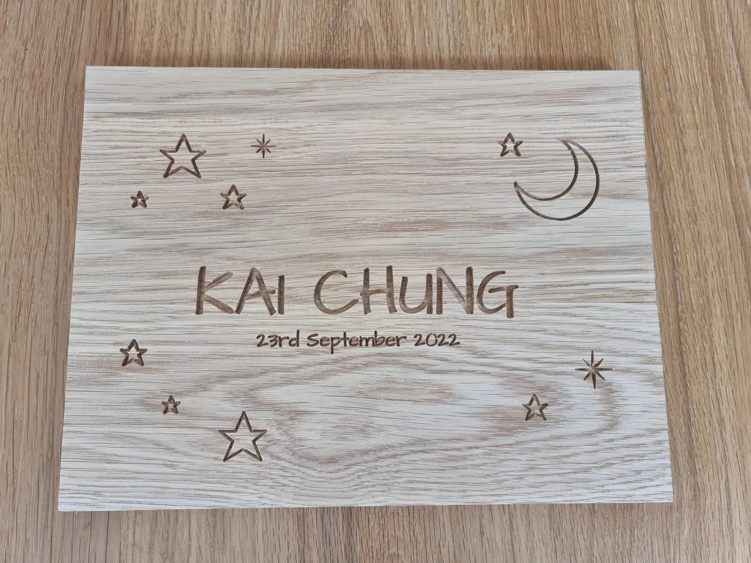 Personalised oak keepsake plaque for a new baby, engraved with stars and a moon