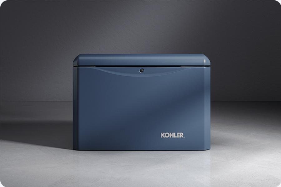A blue Kohler mini fridge with a rounded top and a small round lock on the front, placed on a light-colored floor against a dark wall.