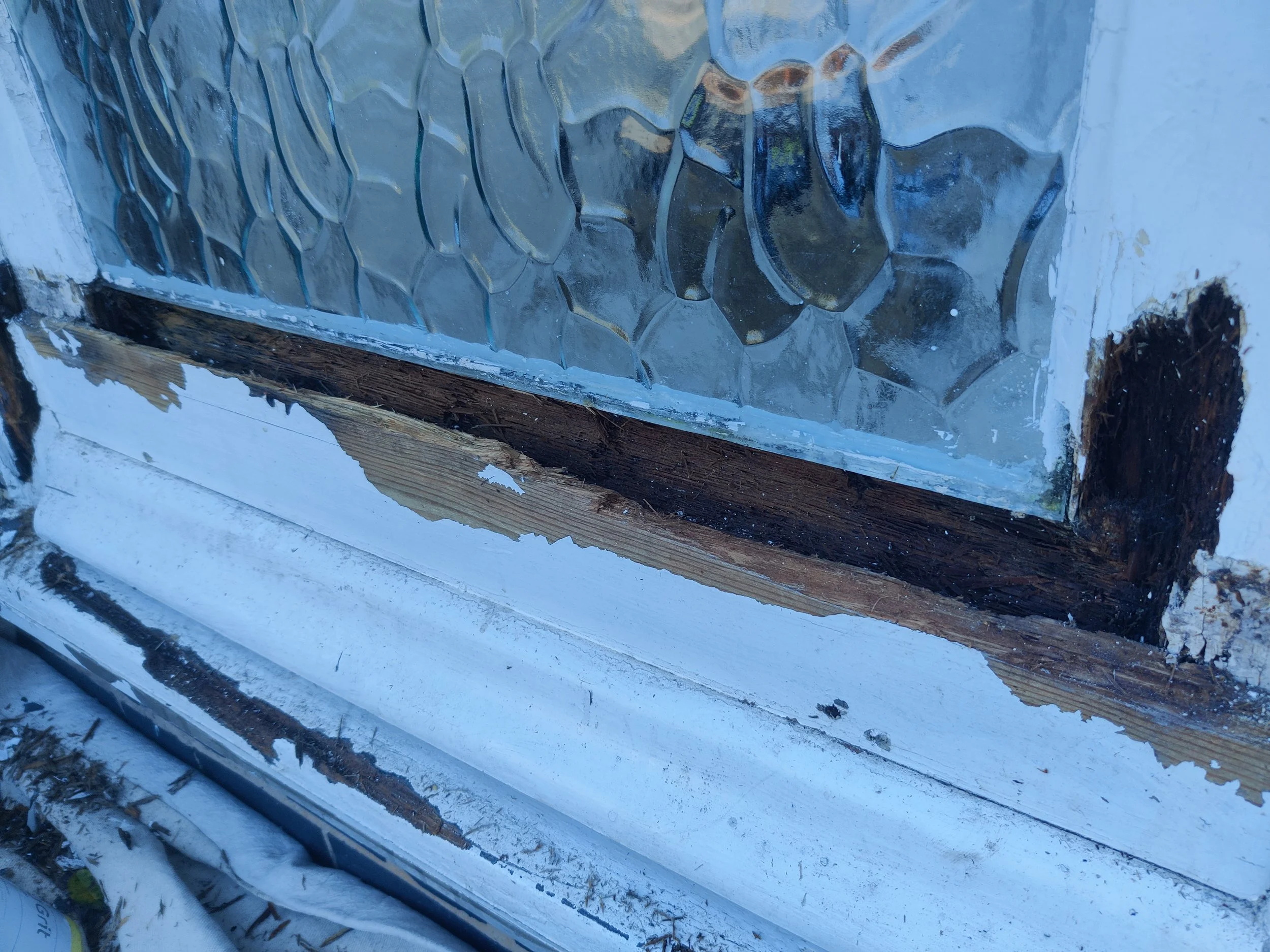 Broken window with cracked glass and wood frame. dry rot timber.