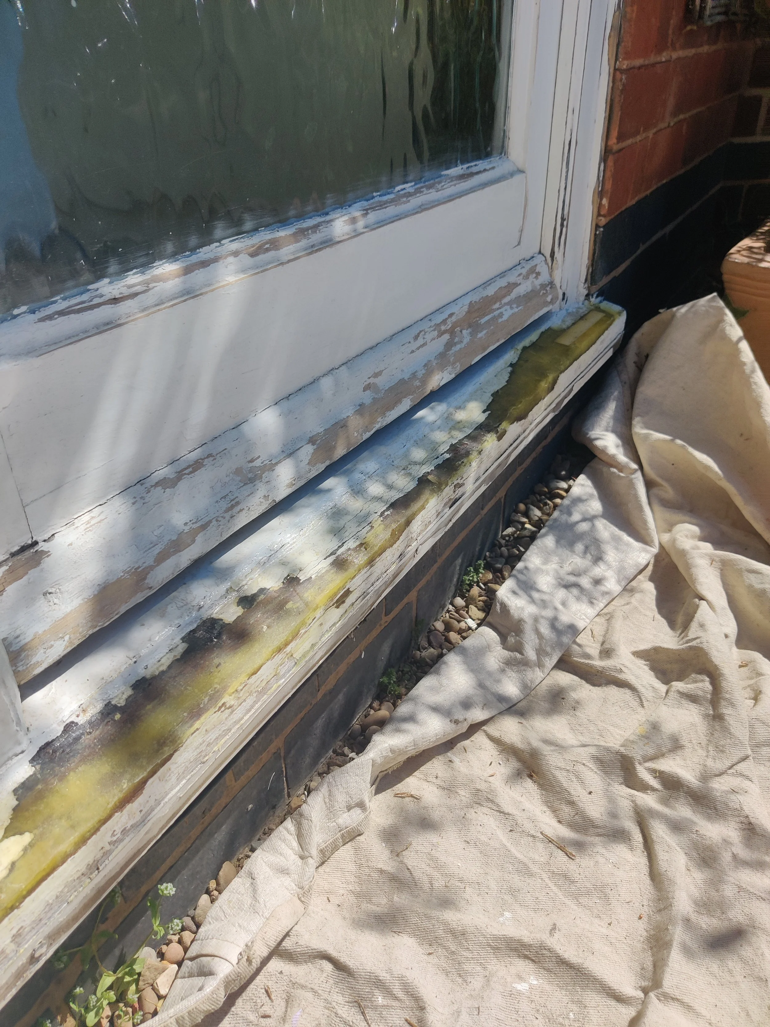 Close-up of a window with rot treatment and epoxy dryflex repair used to recreate the original shape of window frame cill.