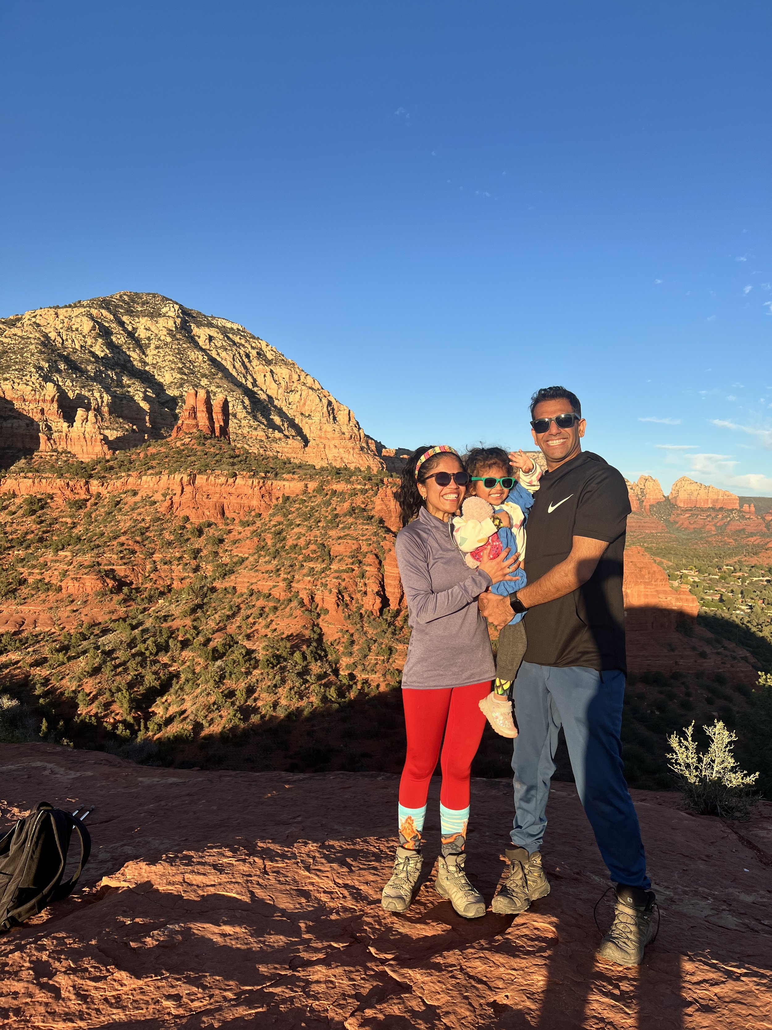 Nishi, her husband, and her daughter on top of a mountain after hiking.