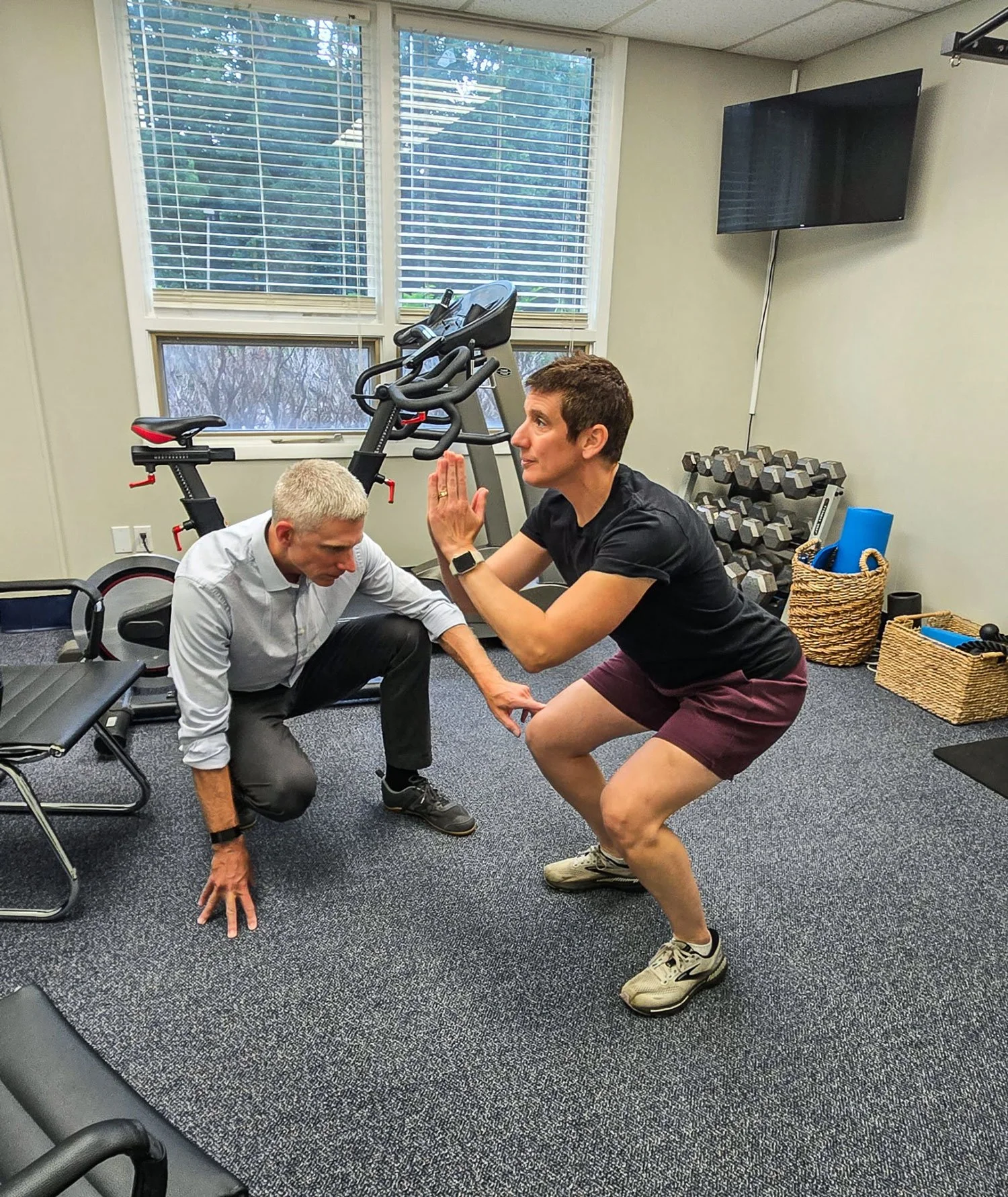 Physician examining knee of squatting patient