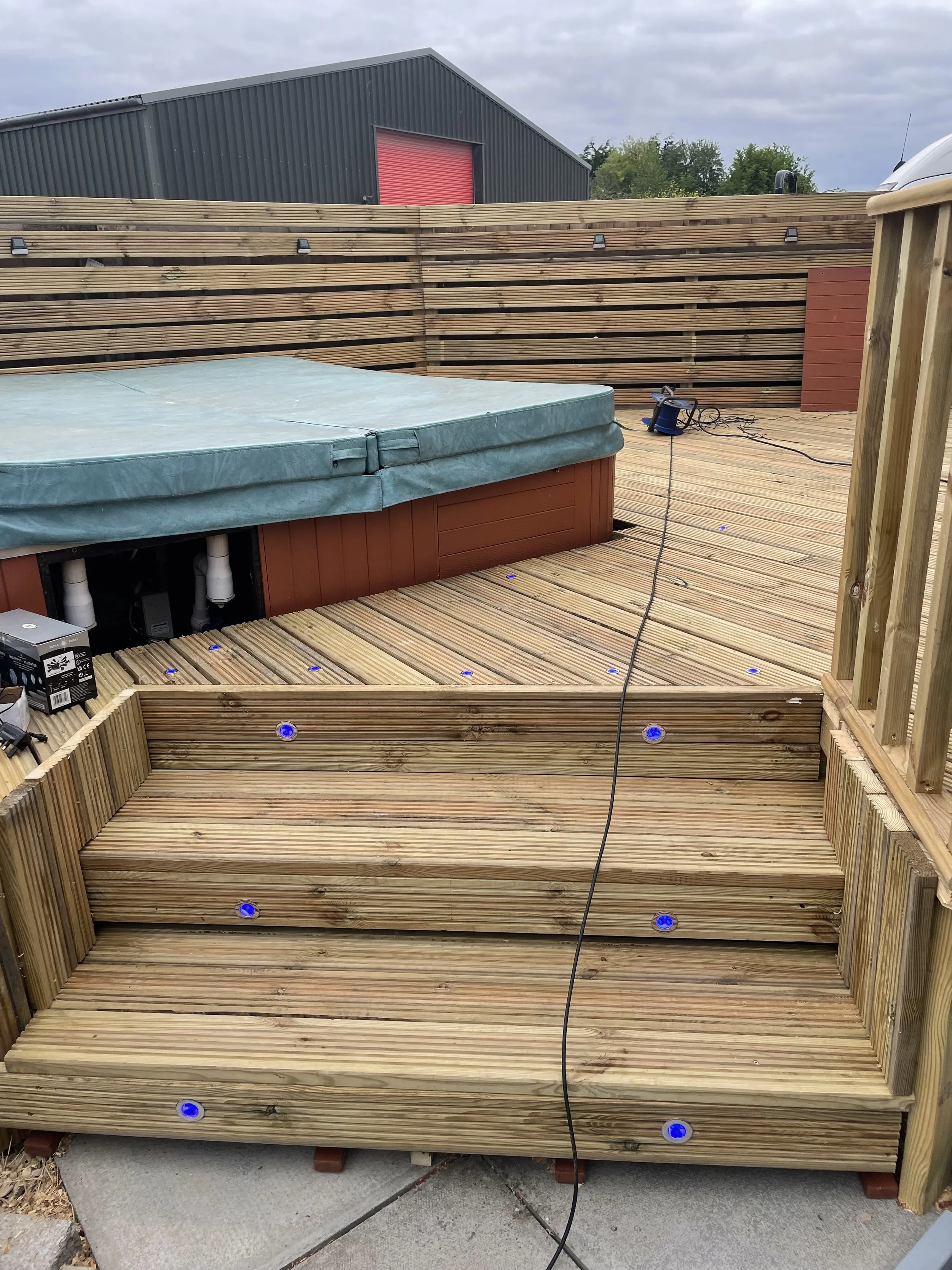 Wooden deck with steps, under construction, with blue LED lights embedded by Britton Landscaping in Bridgwater, Taunton, Highbridge and Burnham