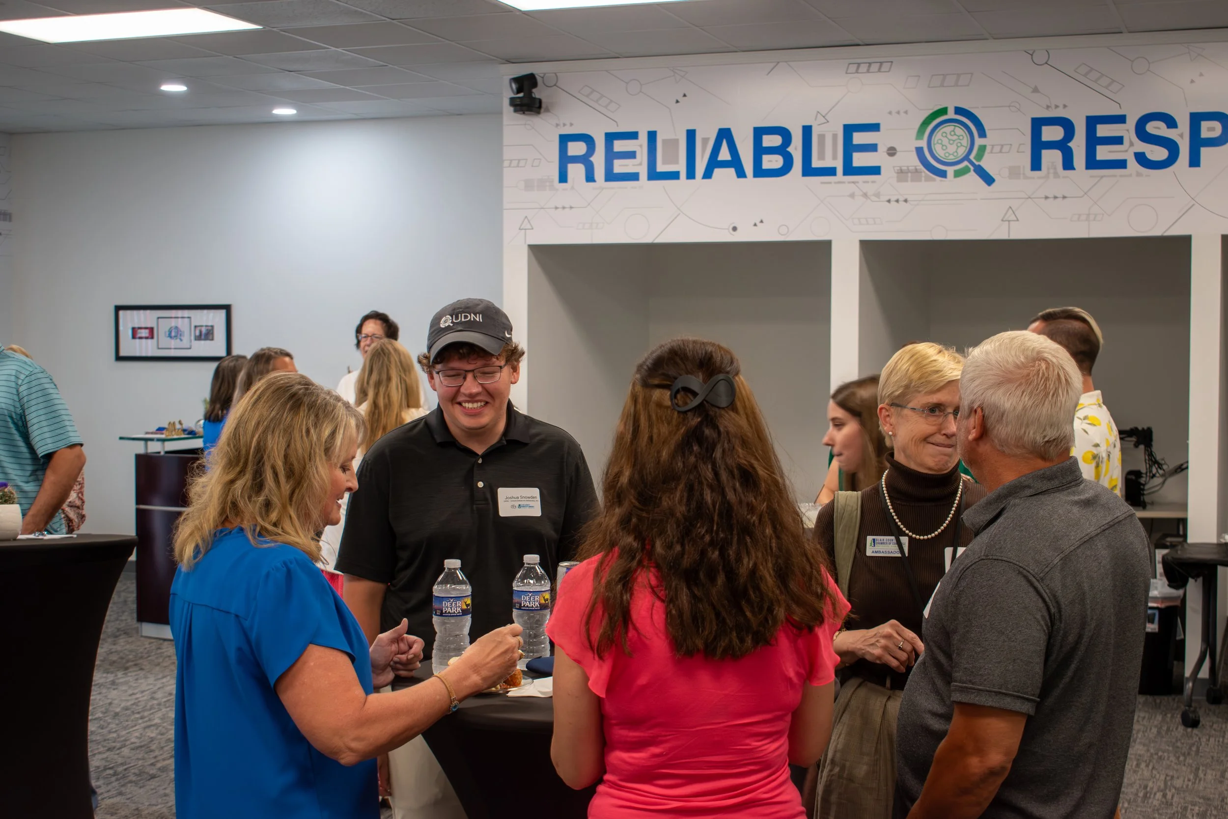 People gathered at a UDNI led networking event in their corporate office in Altoona, PA. Joshua Snowden, a cybersecurity engineer, can be seen engaging in conversation with local business people of Blair County.