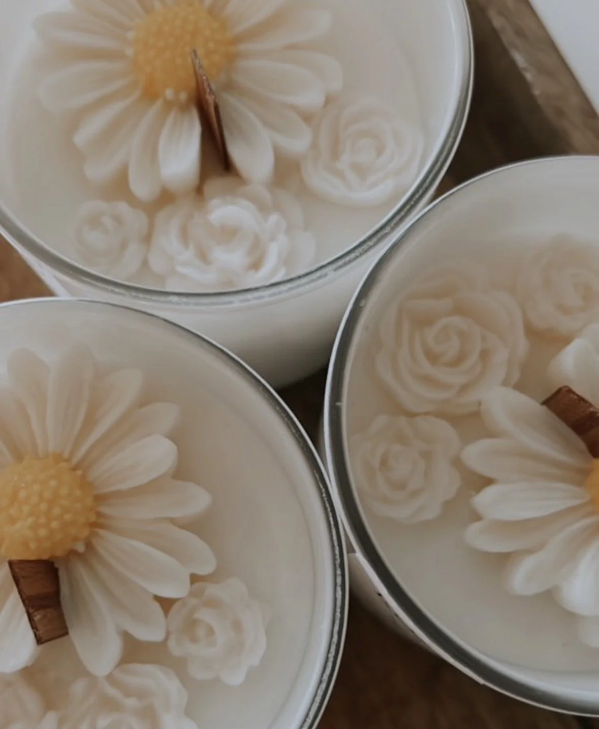 Three glasses of white beverage decorated with daisy flowers and cinnamon sticks.